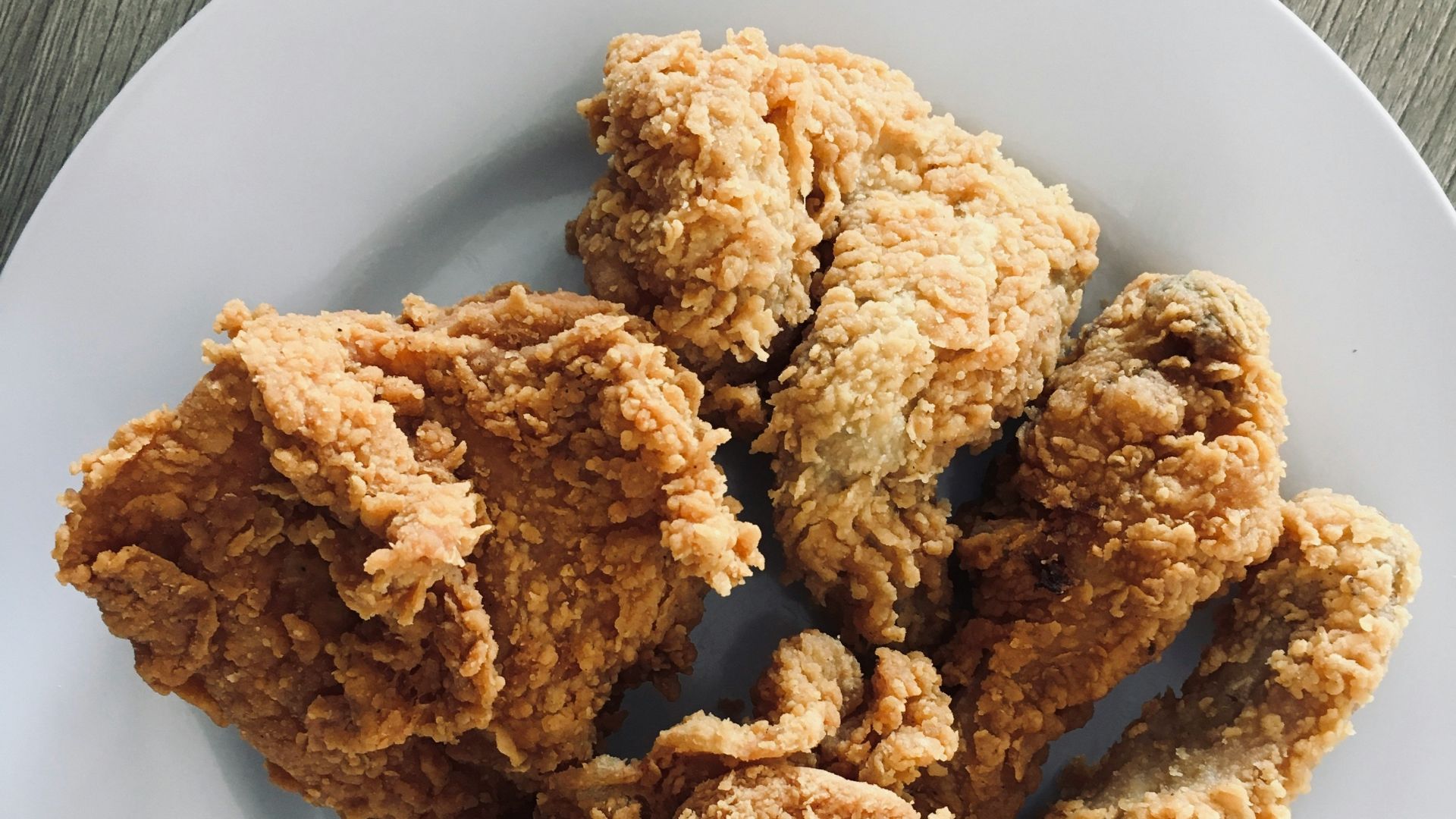 a white plate topped with fried food on top of a wooden table