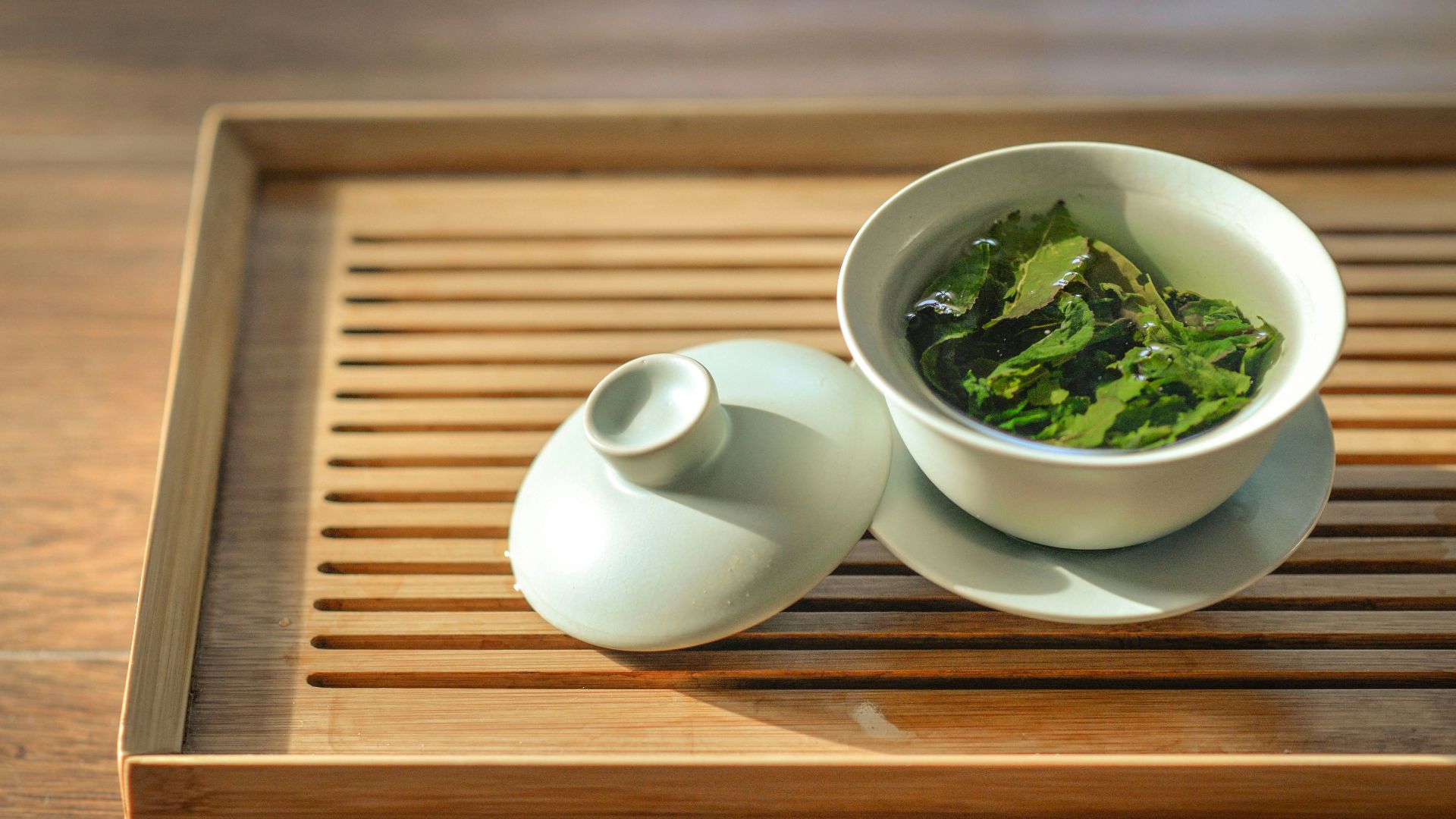 green tea leaves in white ceramic bowl with open lid