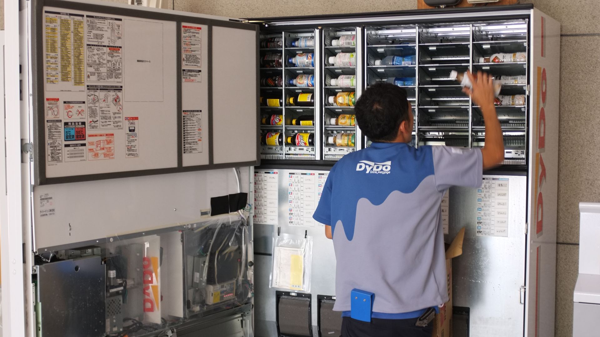 File:Japanese worker changing vending machine beverages (9173452138).jpg