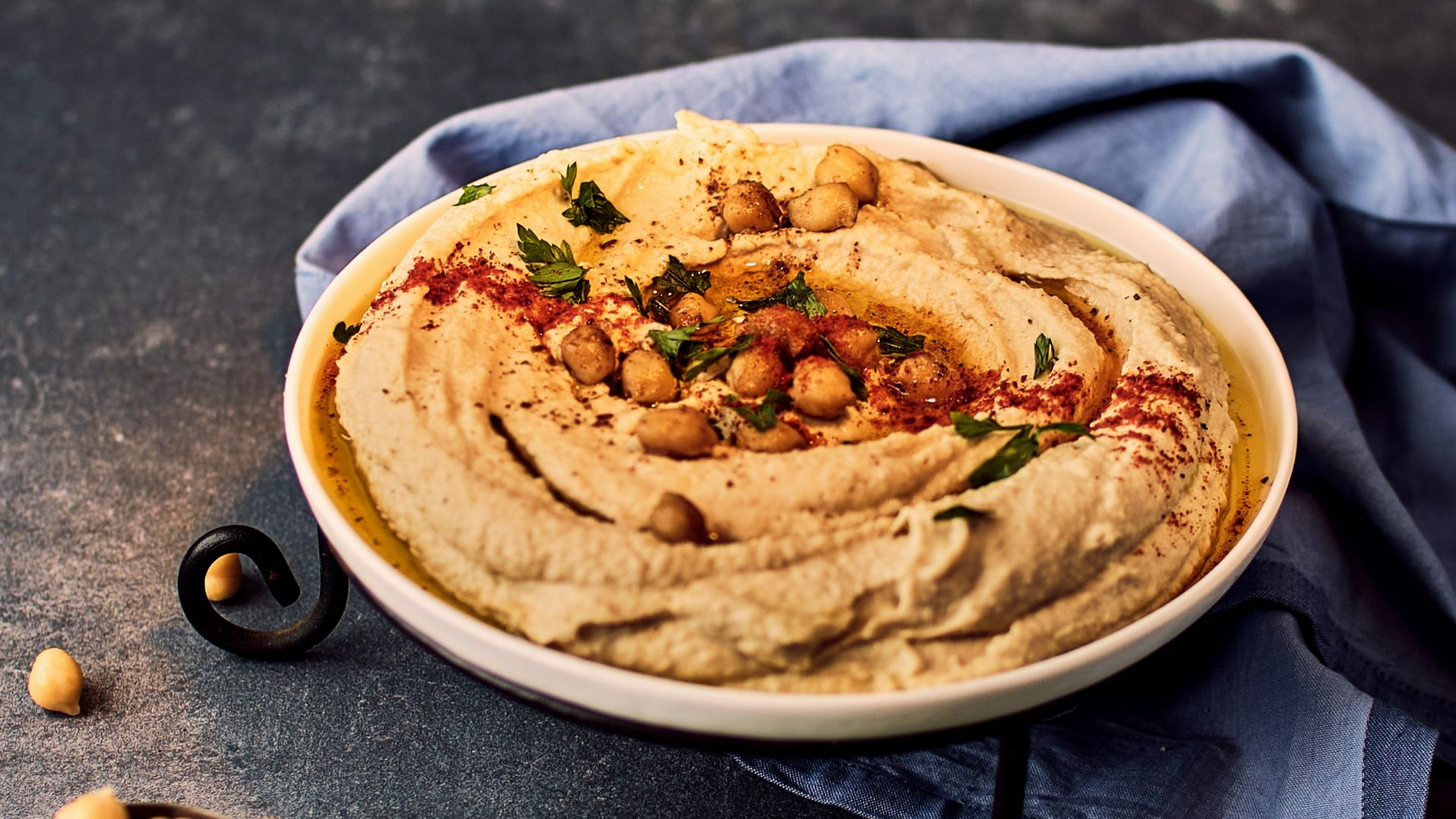 a bowl of hummus with chickpeas on the side