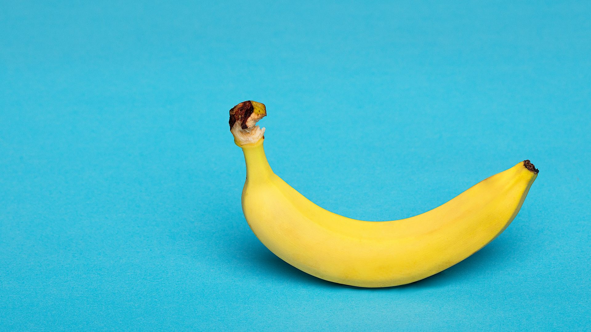 yellow banana fruit on blue surface