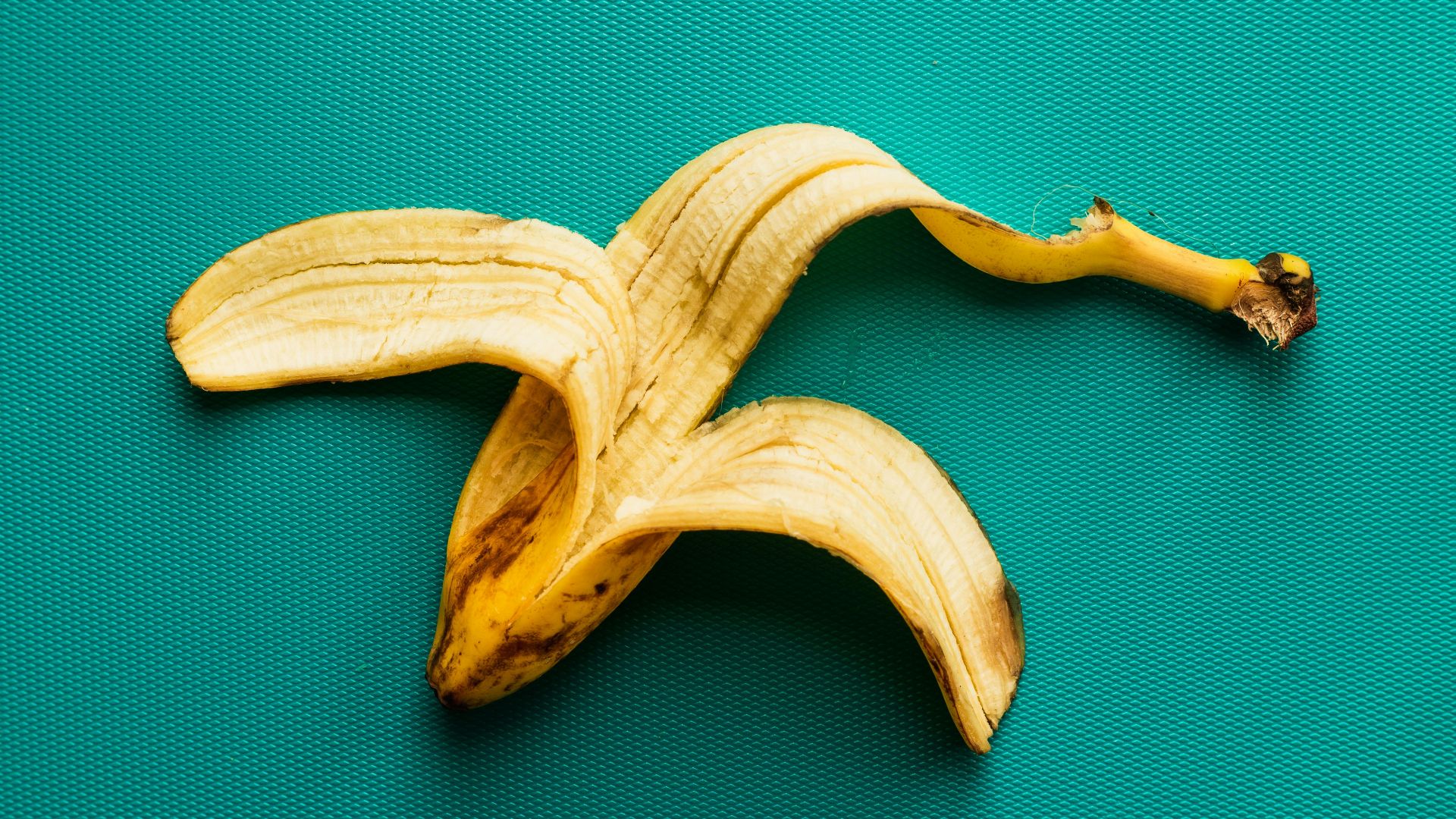 a peeled banana sitting on top of a green surface