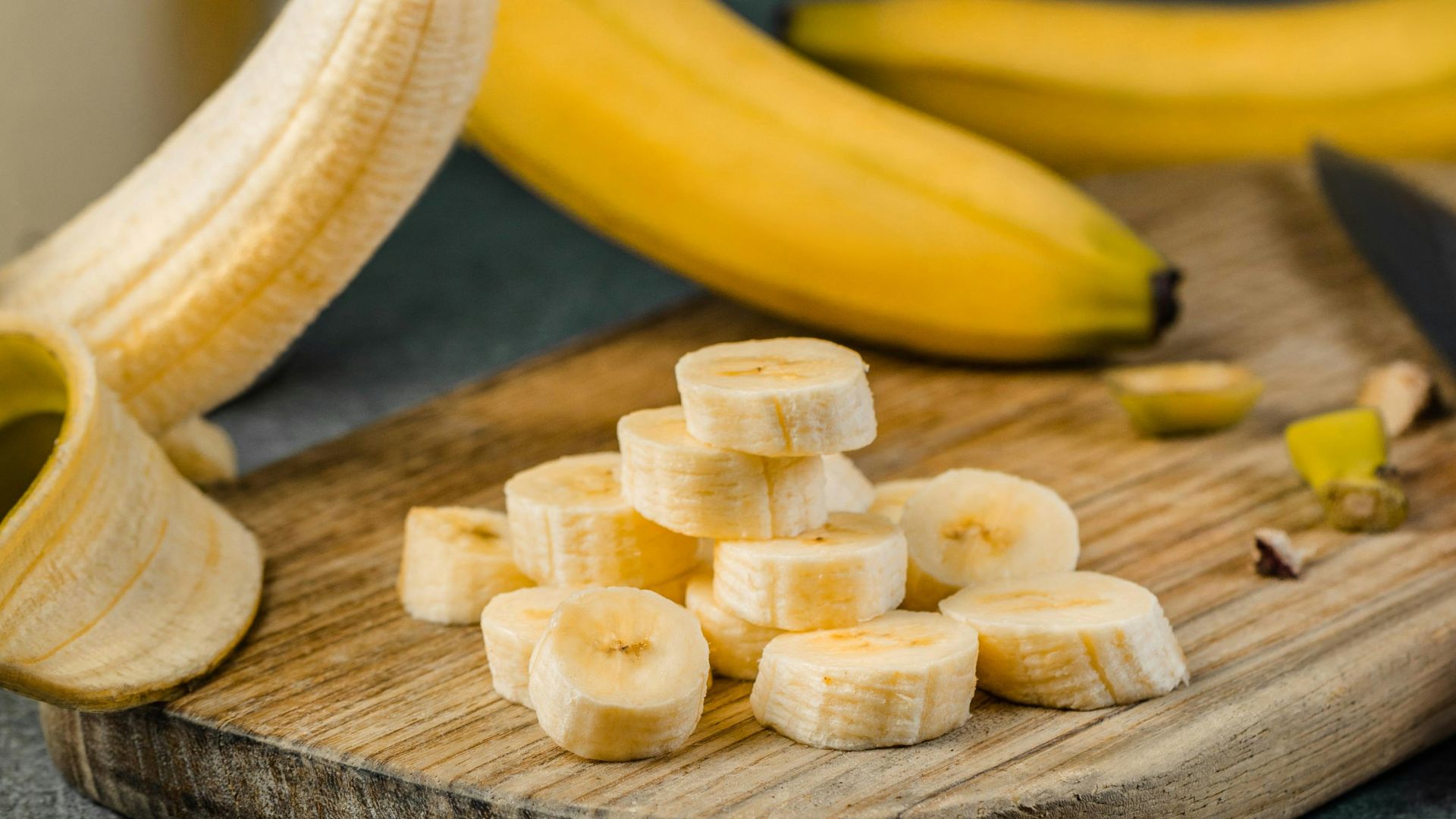 yellow banana fruit on brown wooden chopping board