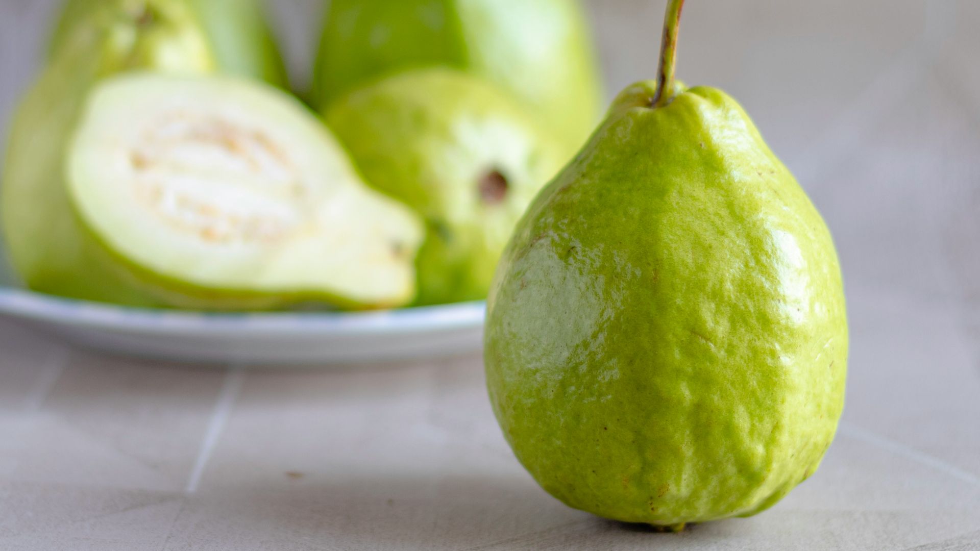 green fruit on white ceramic plate