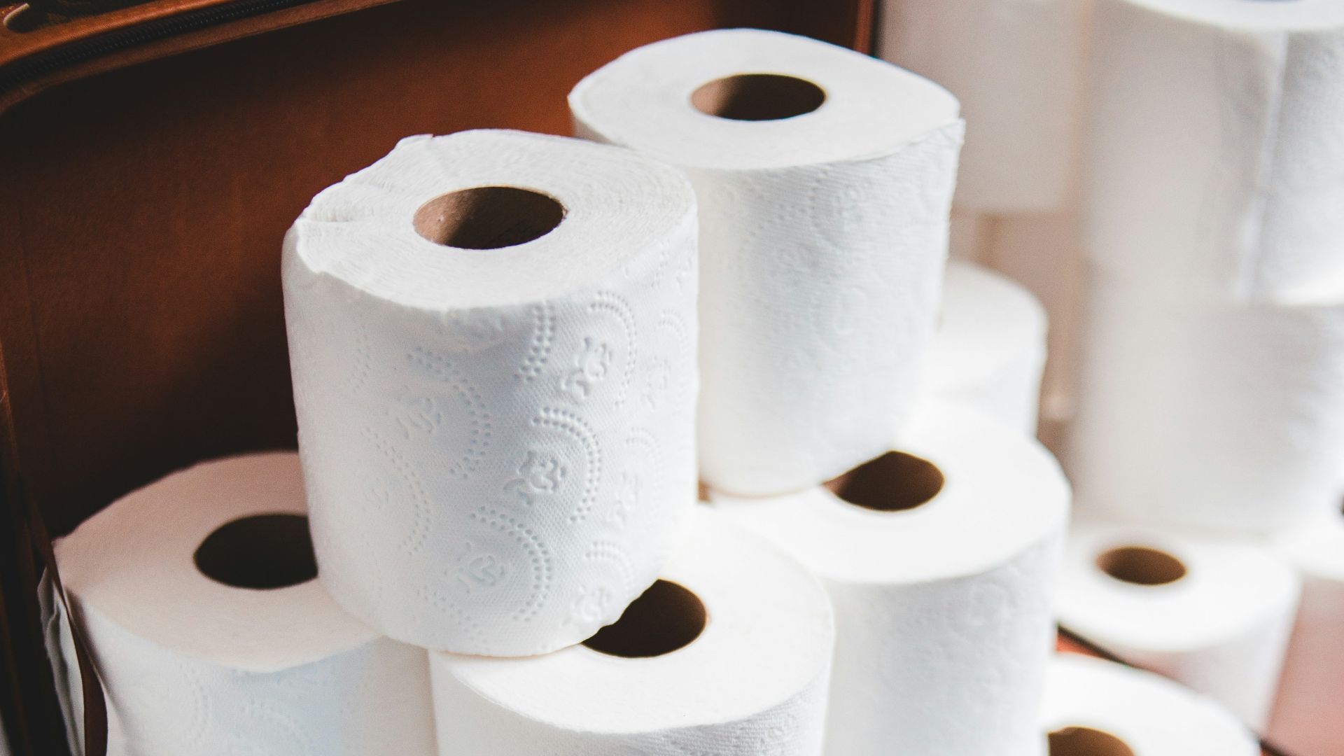 white toilet paper roll on brown wooden table