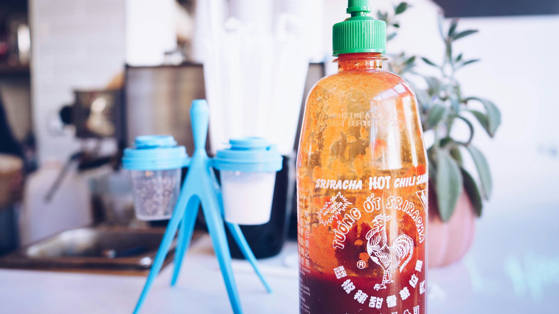 half-filled bottle beside cup rack
