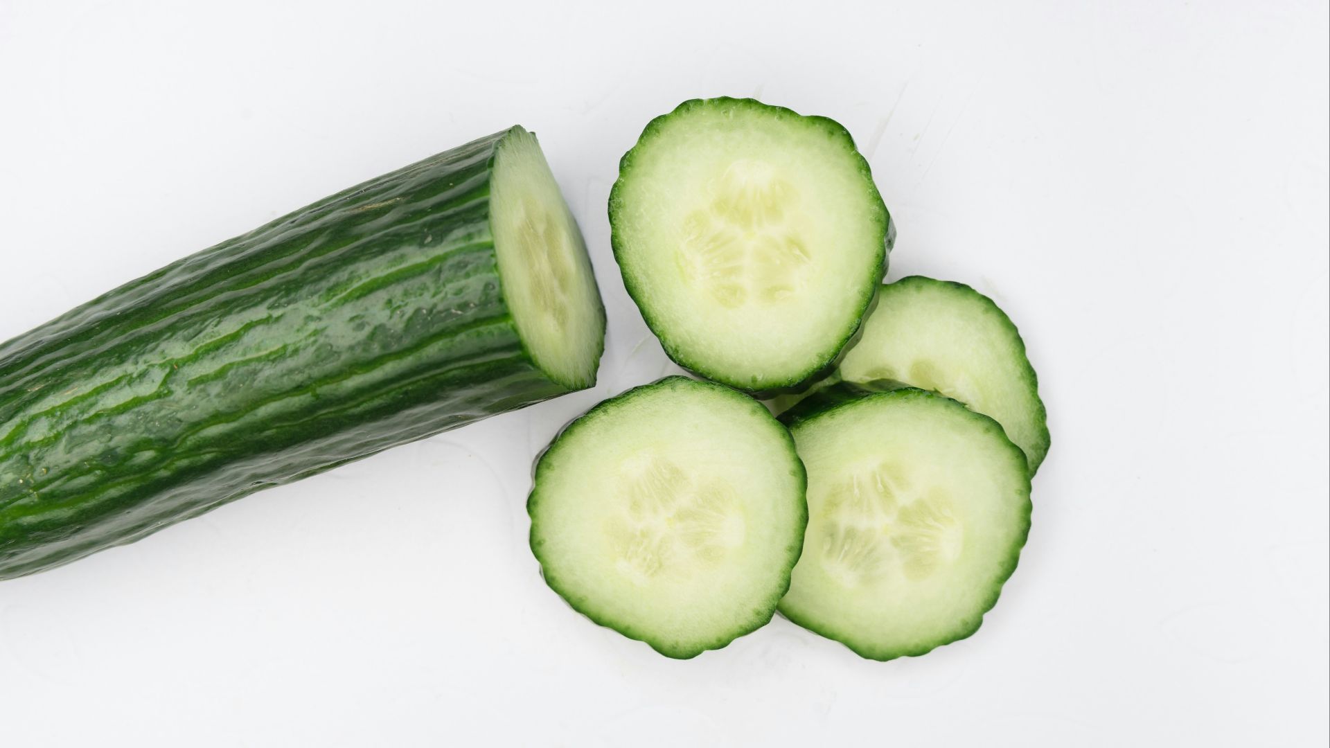 sliced cucumber on white surface