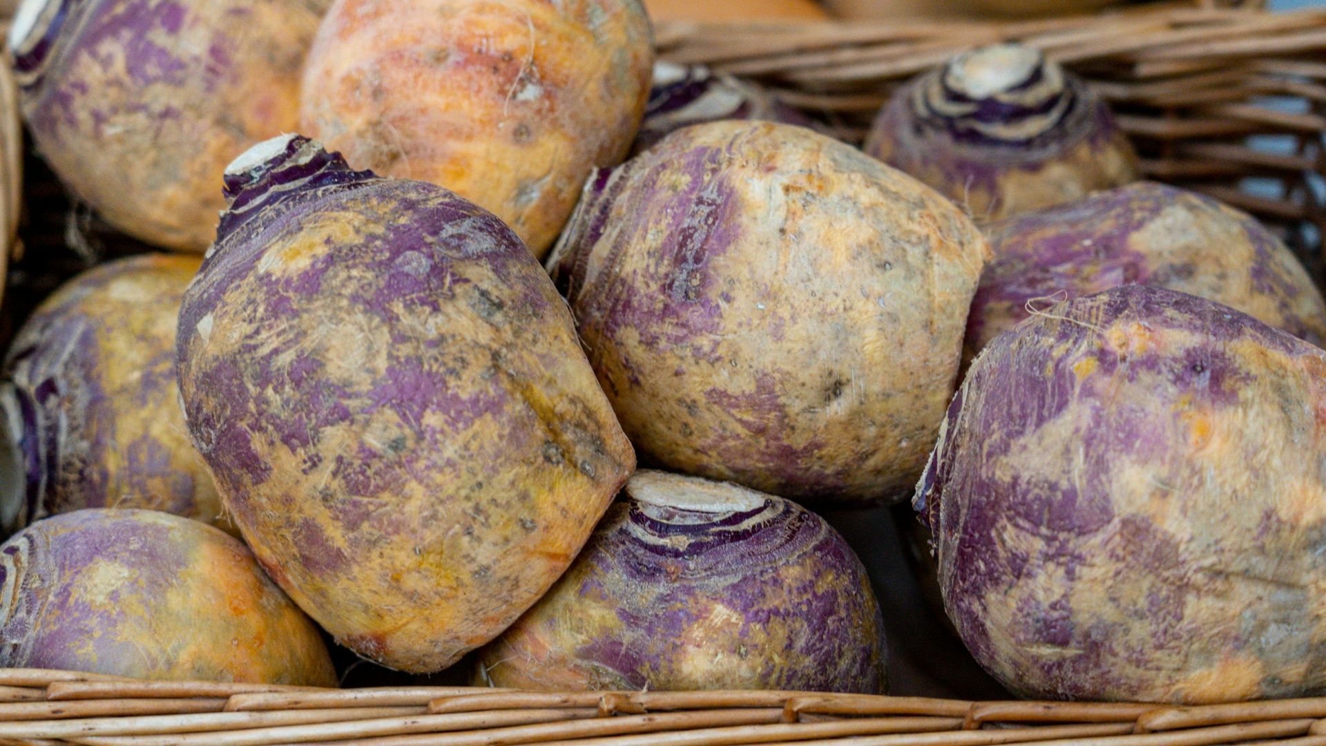 a basket filled with purple potatoes sitting on top of a table