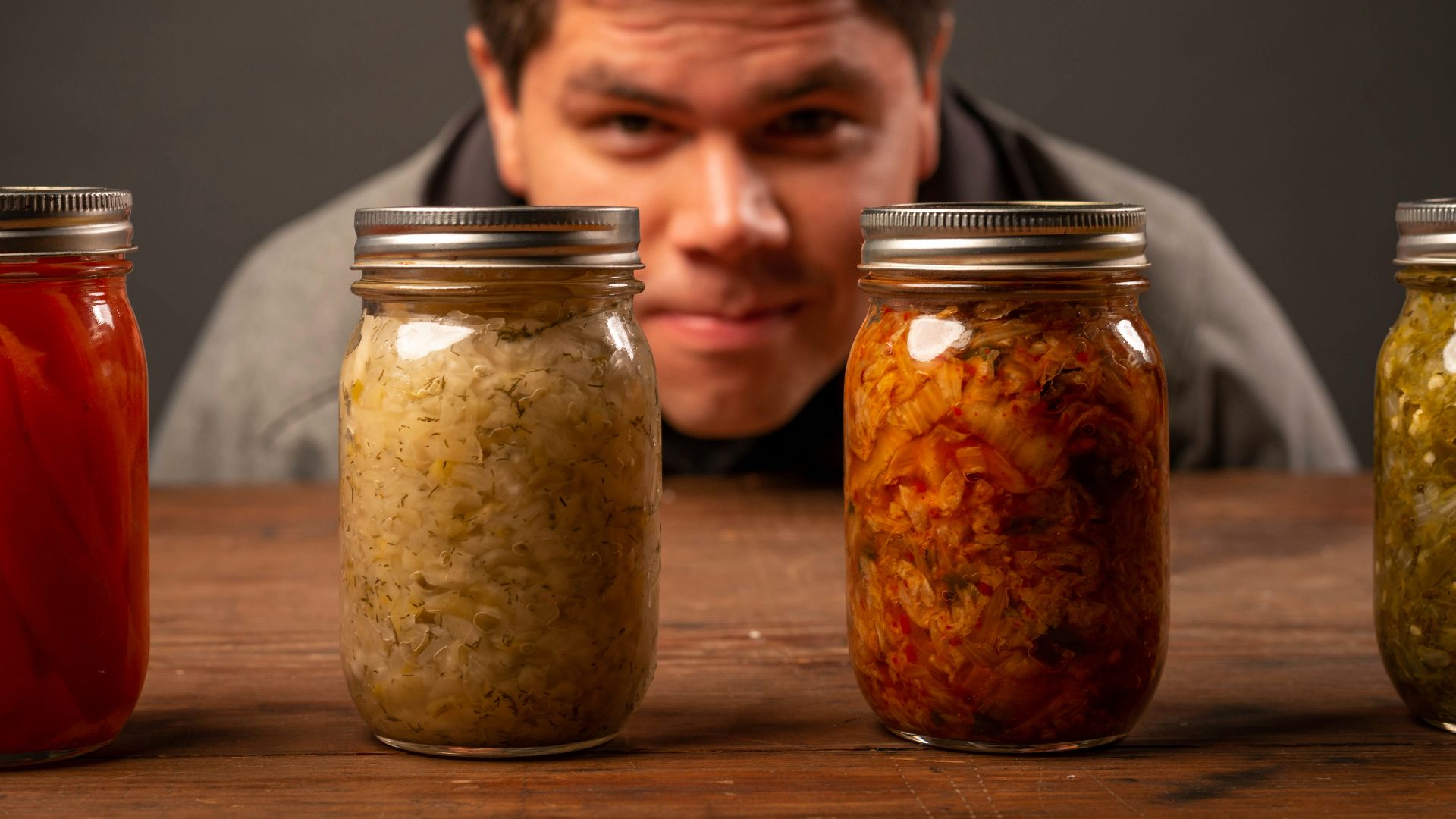 man in black shirt sitting beside brown wooden table
