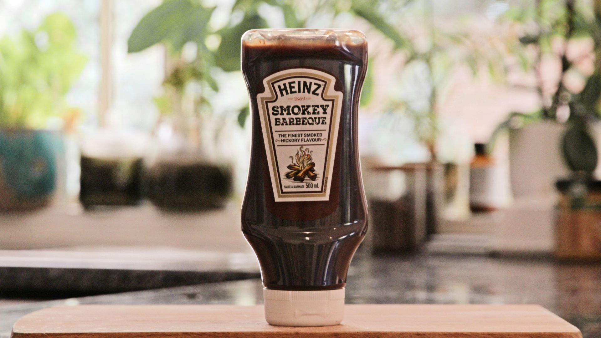 a bottle of ketchup sitting on top of a cutting board
