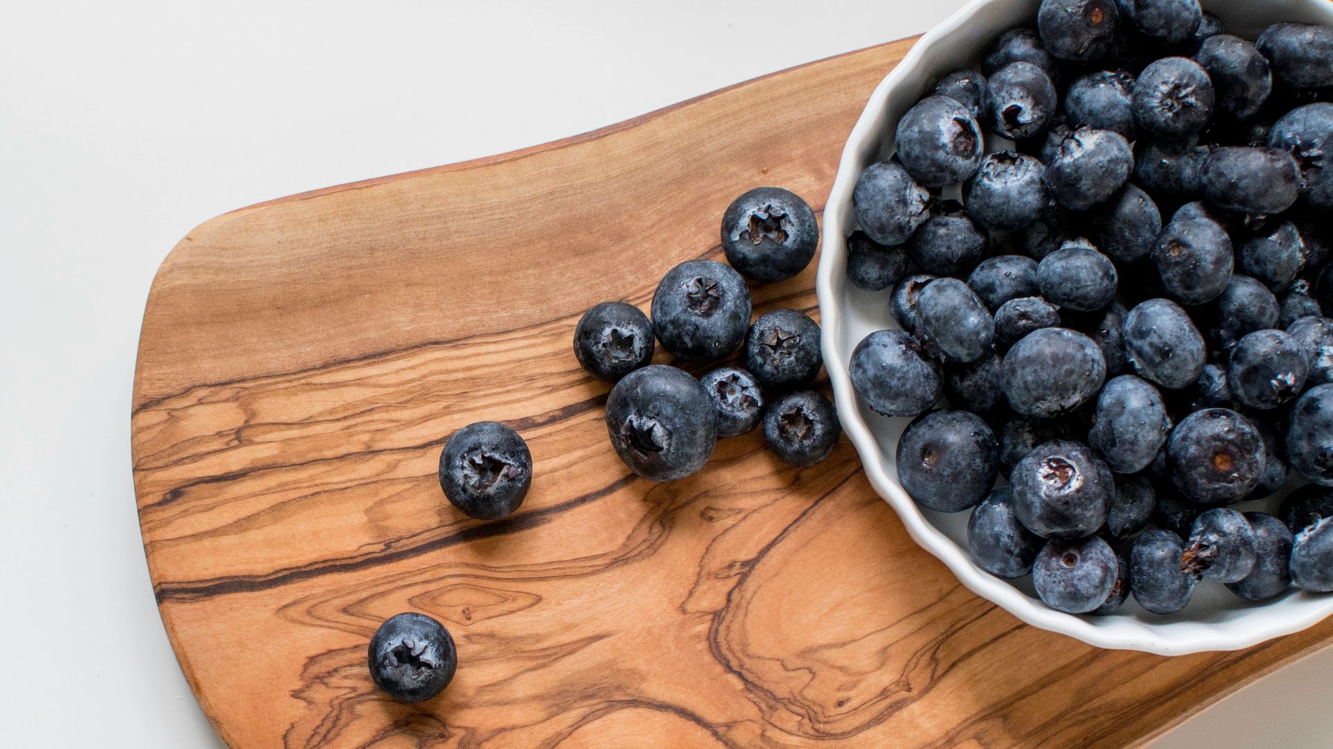 black berries on brown wooden chopping board