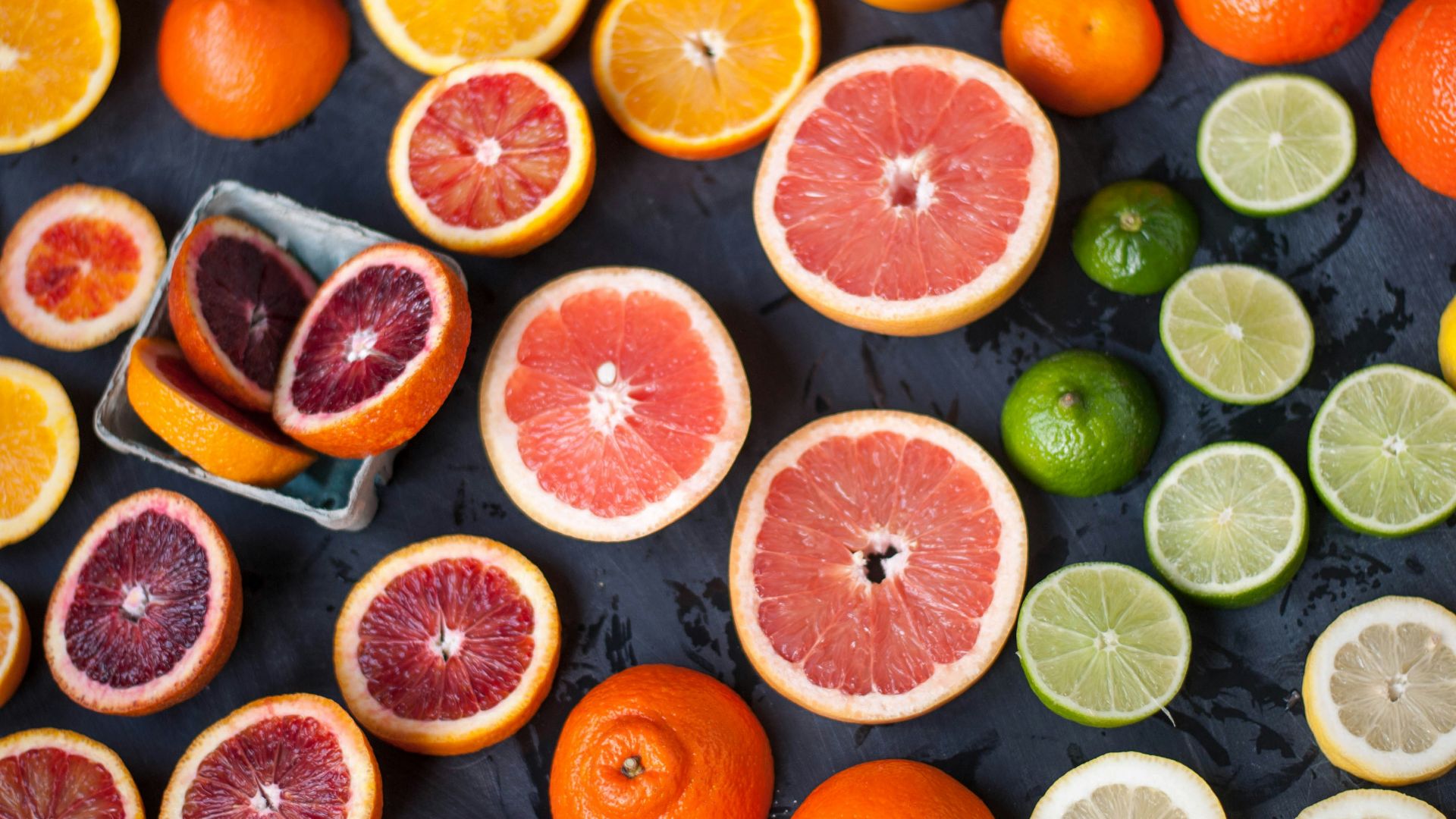 sliced orange fruits on black surface