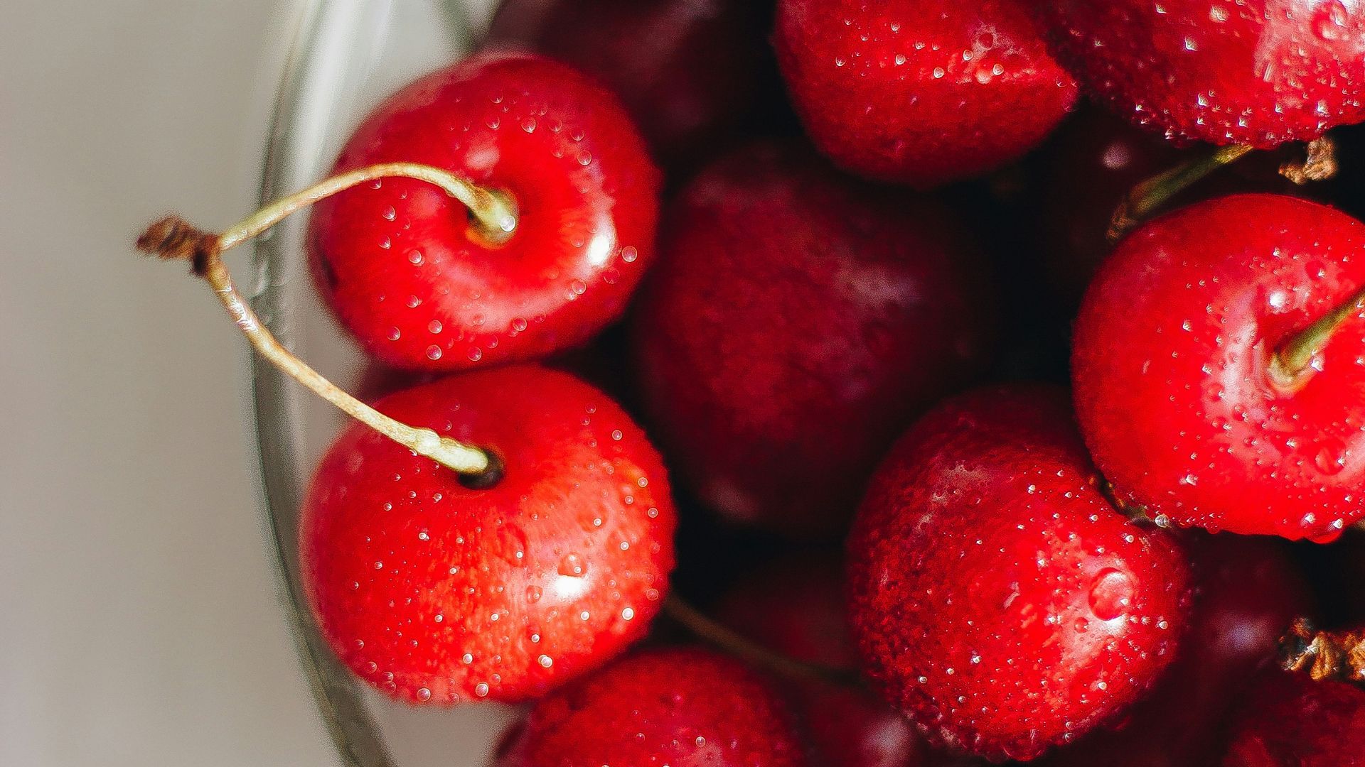 red cherries in clear glass bowl