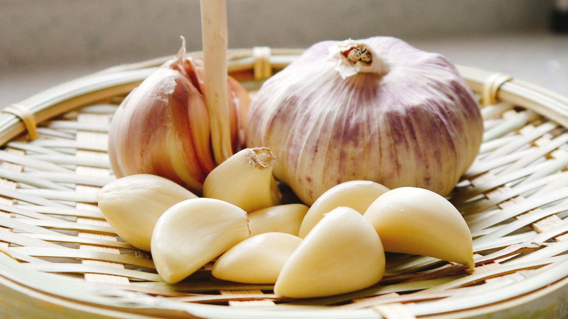 a basket of garlic and garlic bulbs on a counter