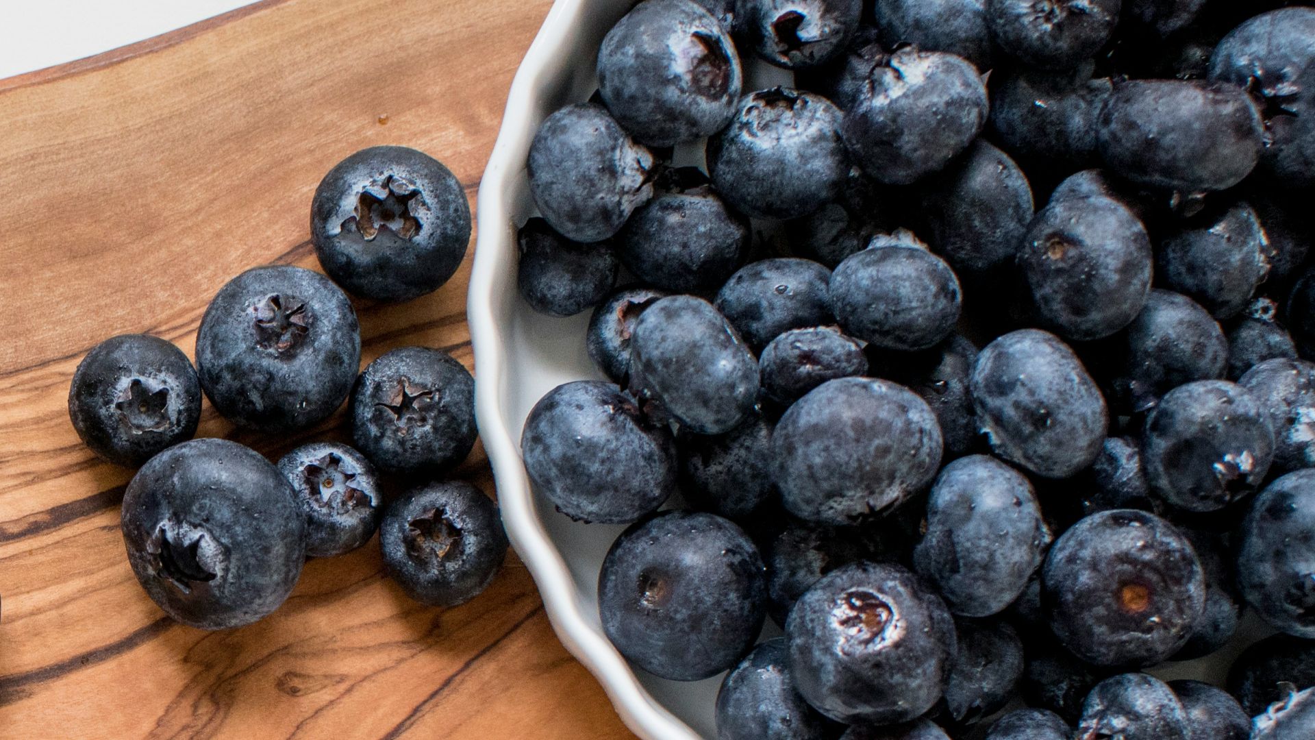 black berries on brown wooden chopping board