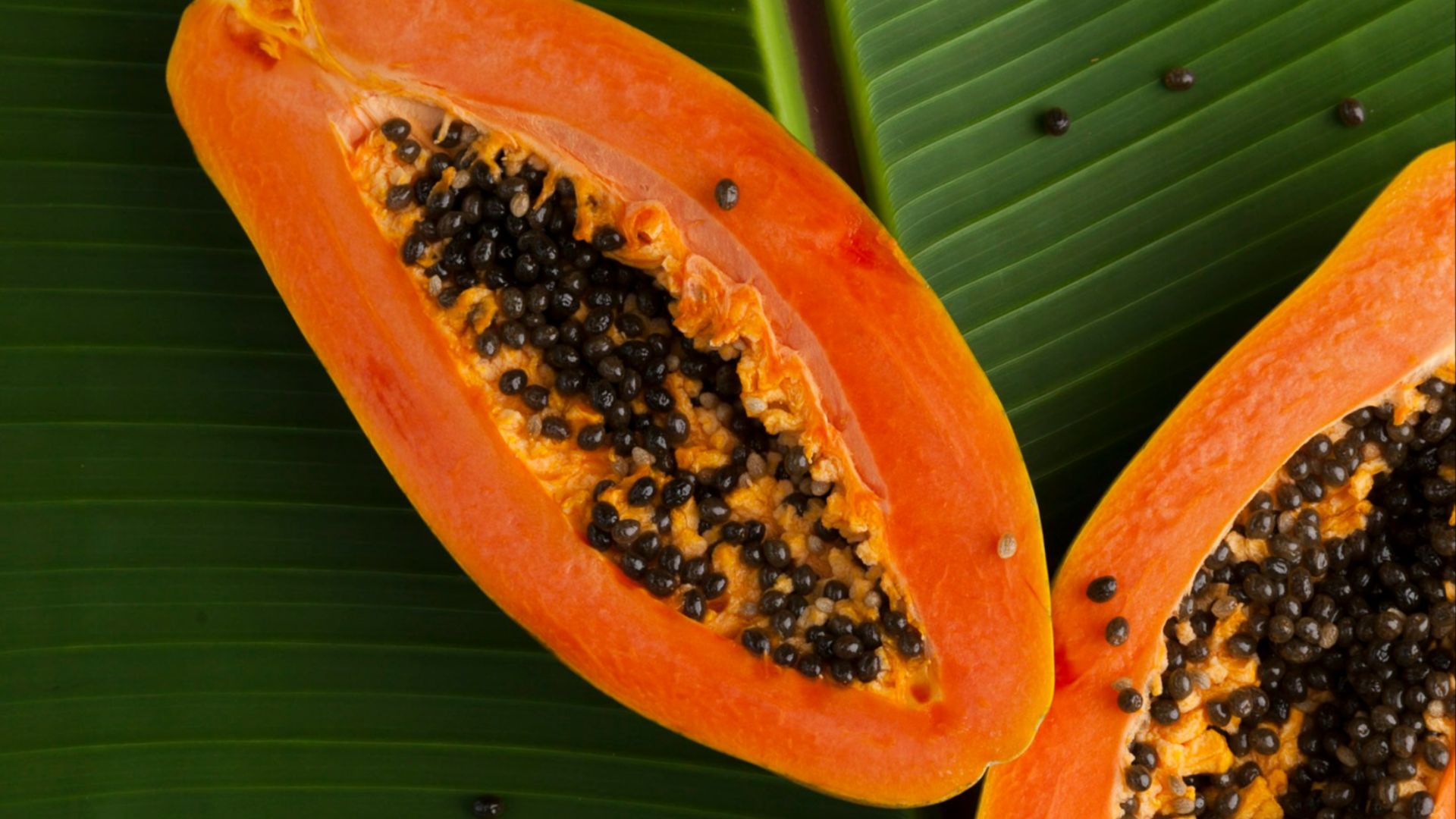 sliced papaya on green banana leaf