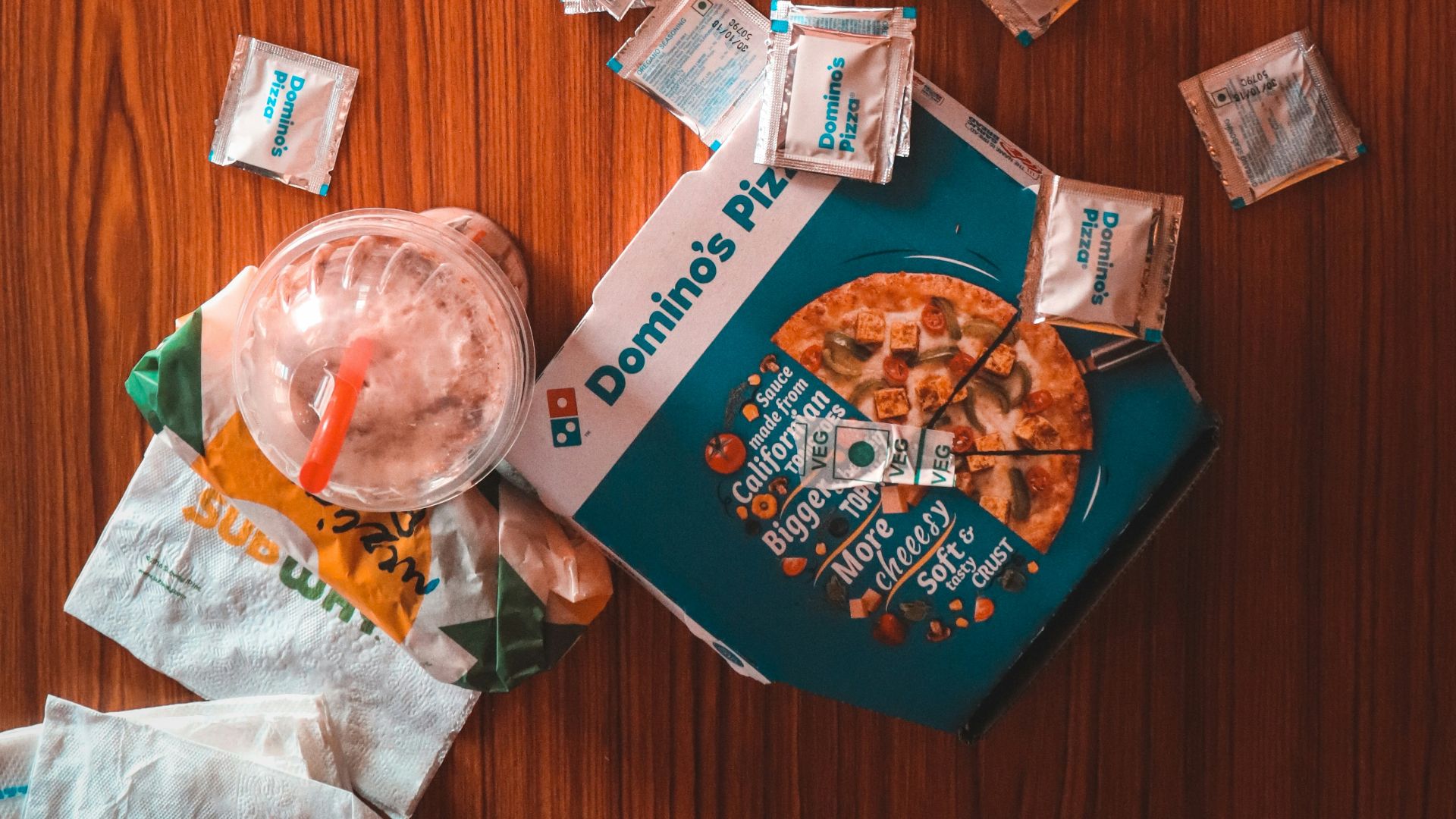 pizza and sauce packs beside iPhone on table