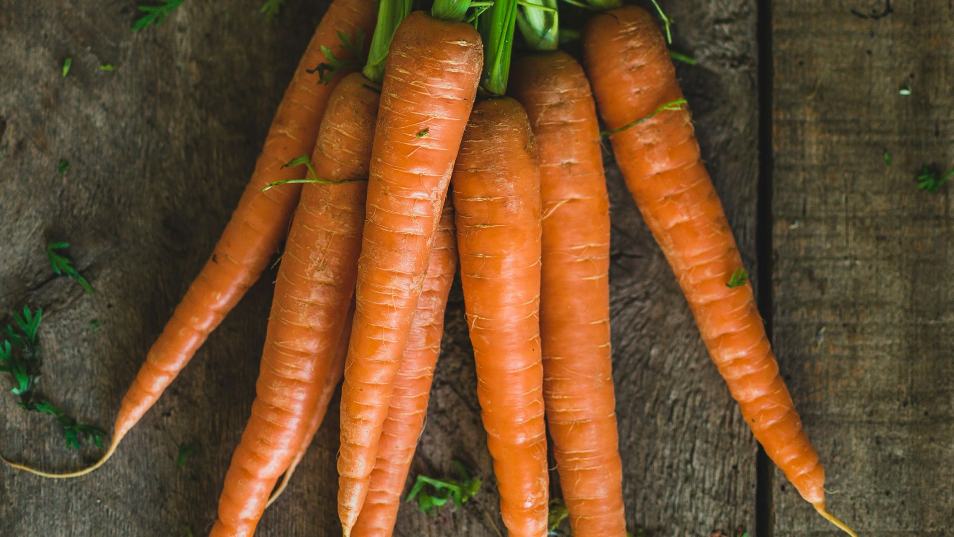 a bunch of carrots sitting on top of a wooden table