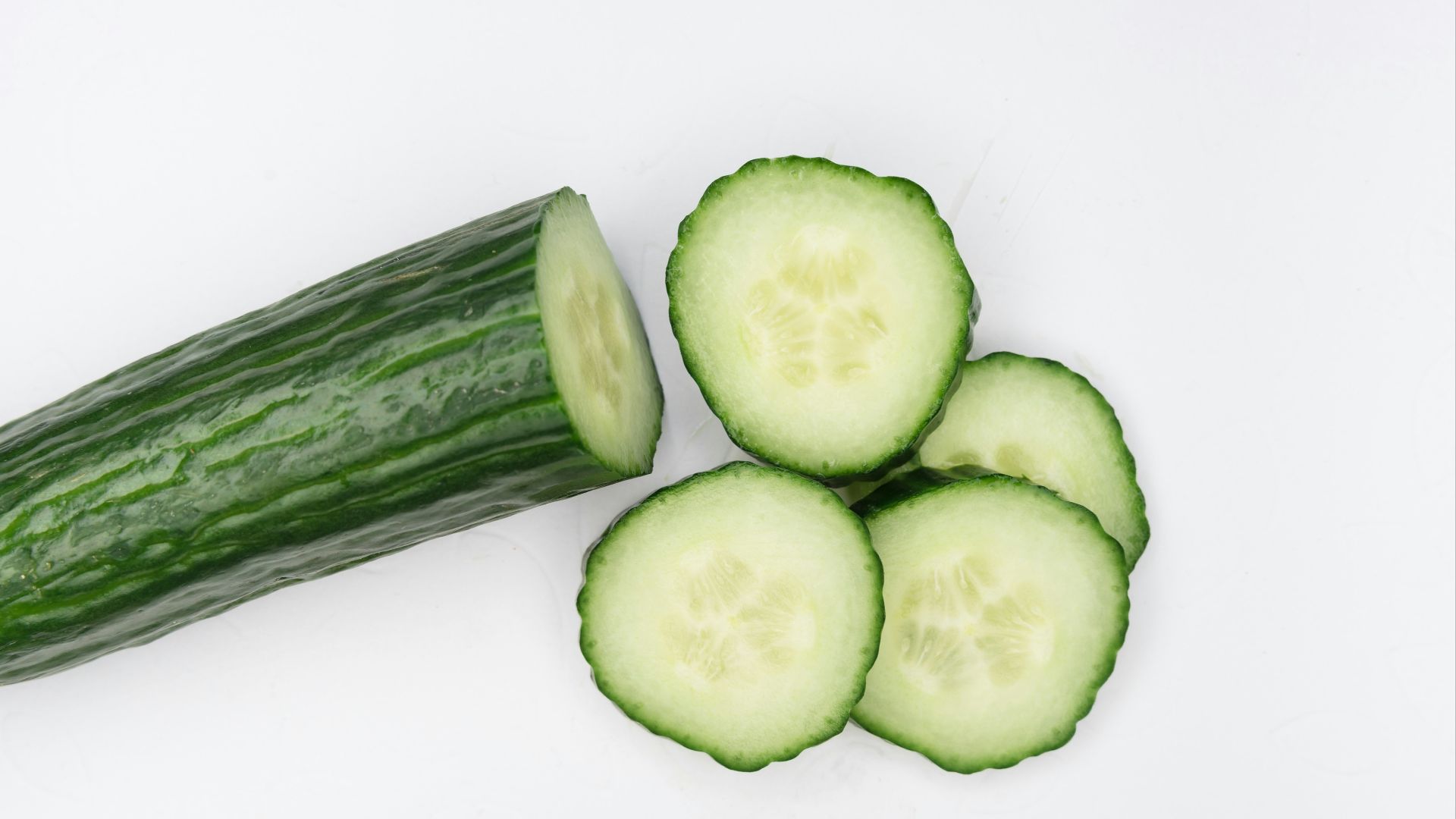 sliced cucumber on white surface