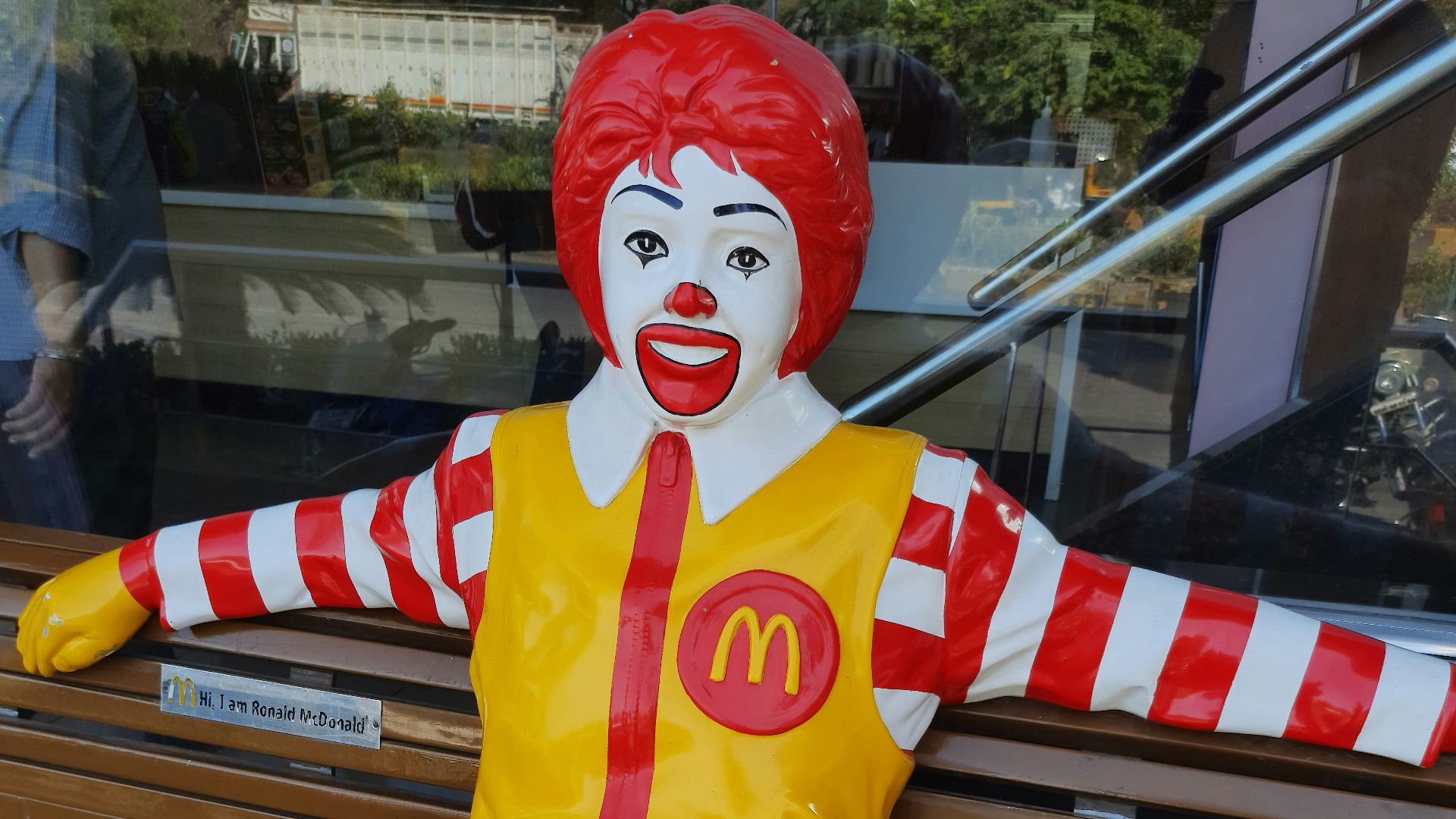 a statue of a ronald mcdonald sitting on a bench