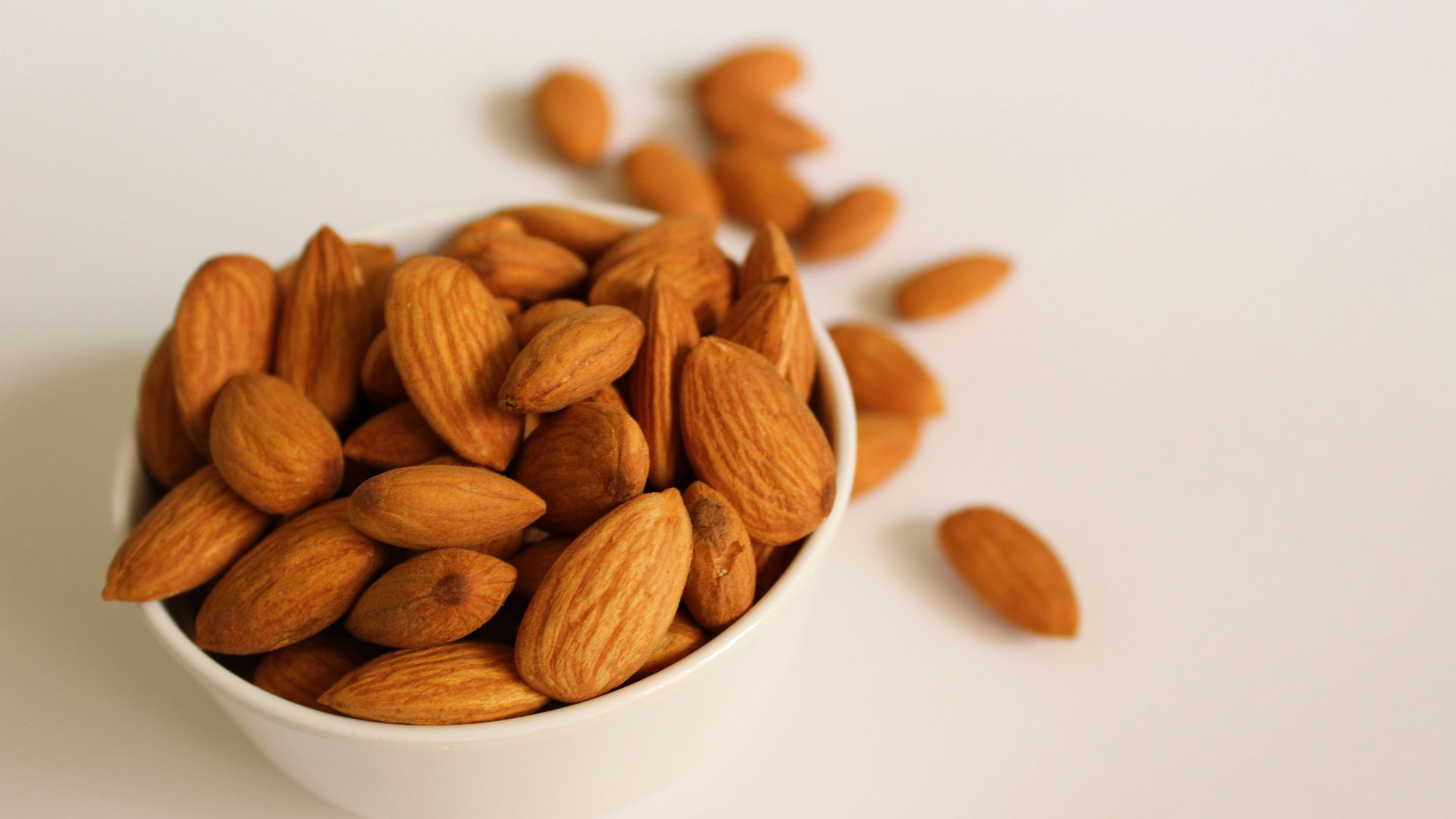 brown almond nuts on white ceramic bowl