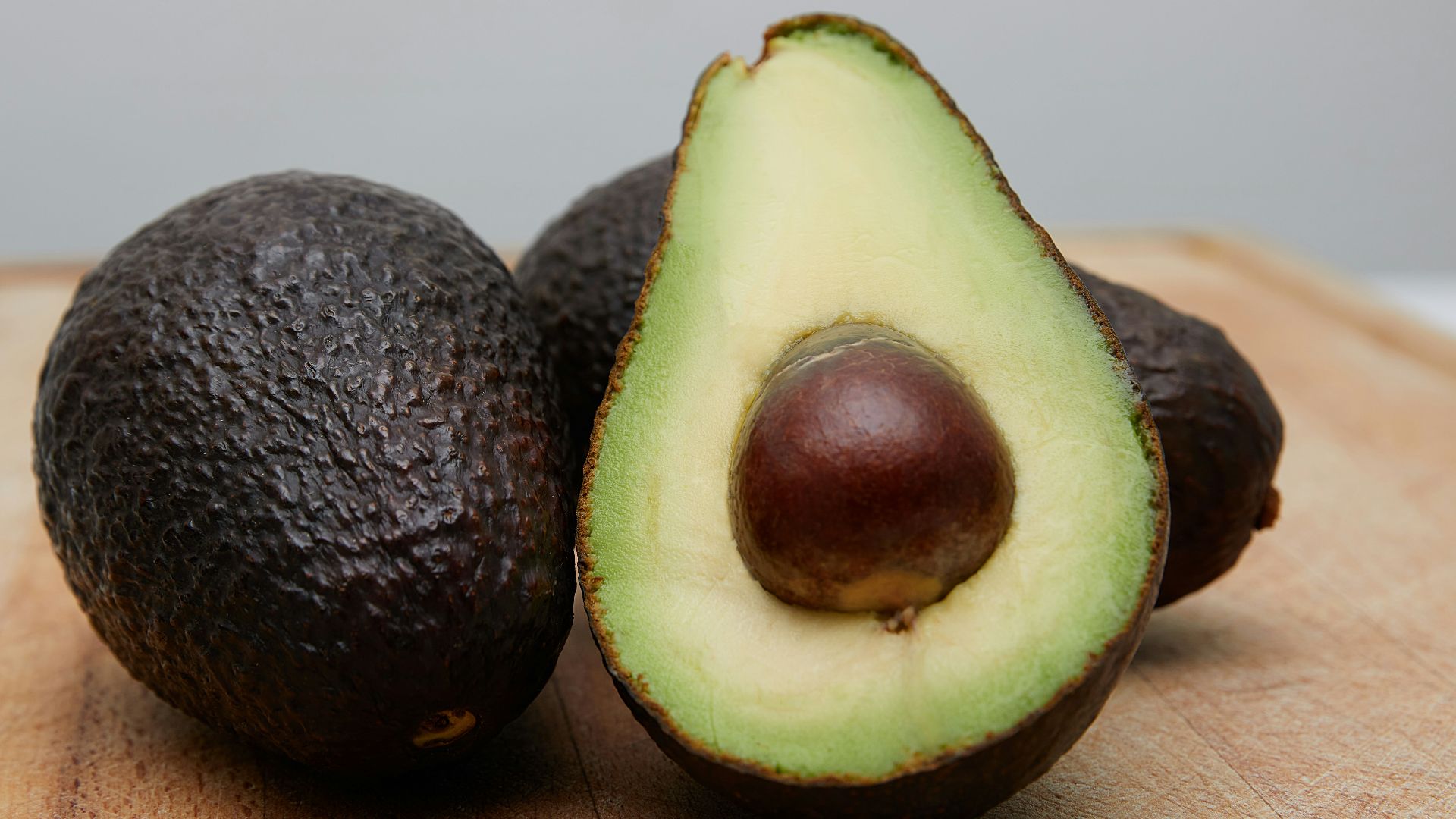 sliced avocado fruit on brown wooden table