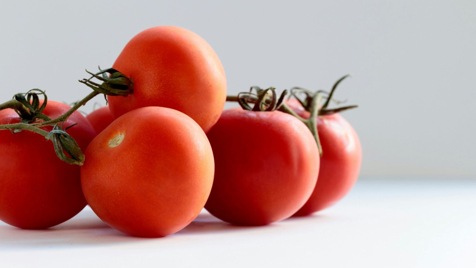 red tomato on white surface