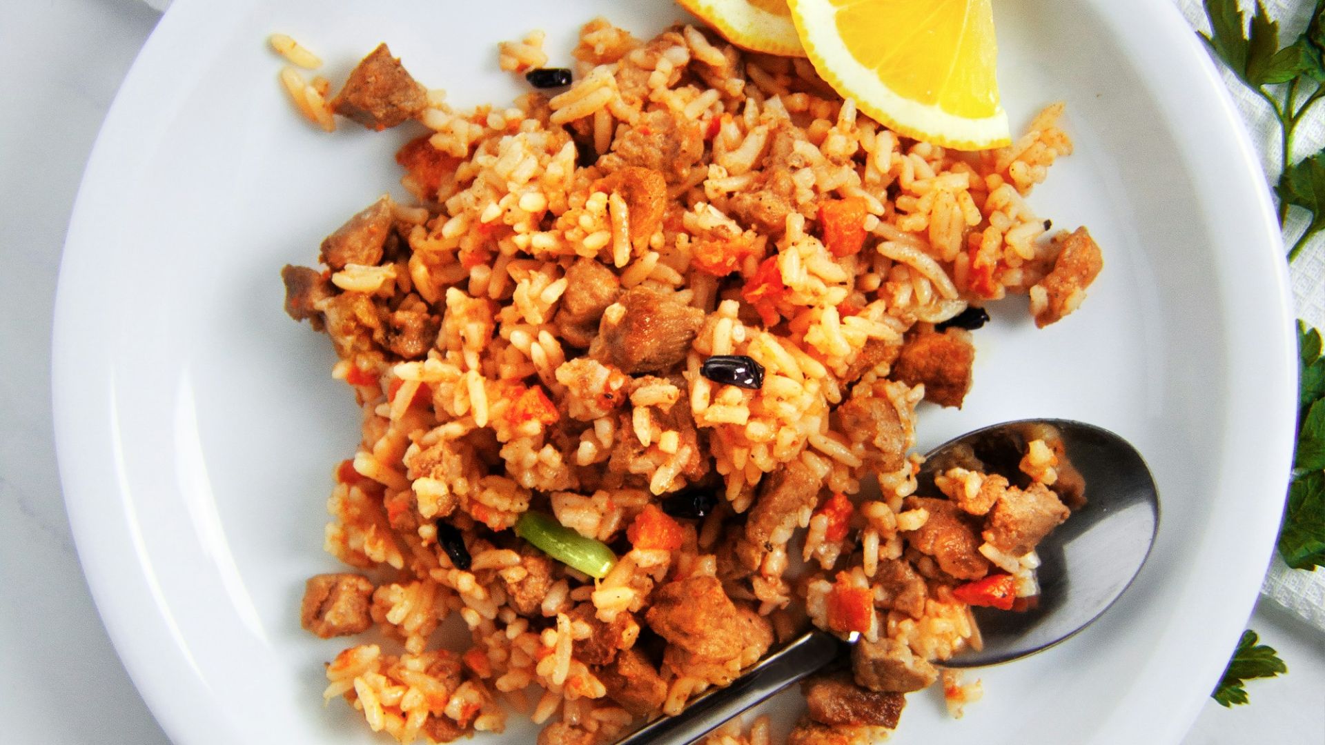 fried rice with sliced lemon on white ceramic plate