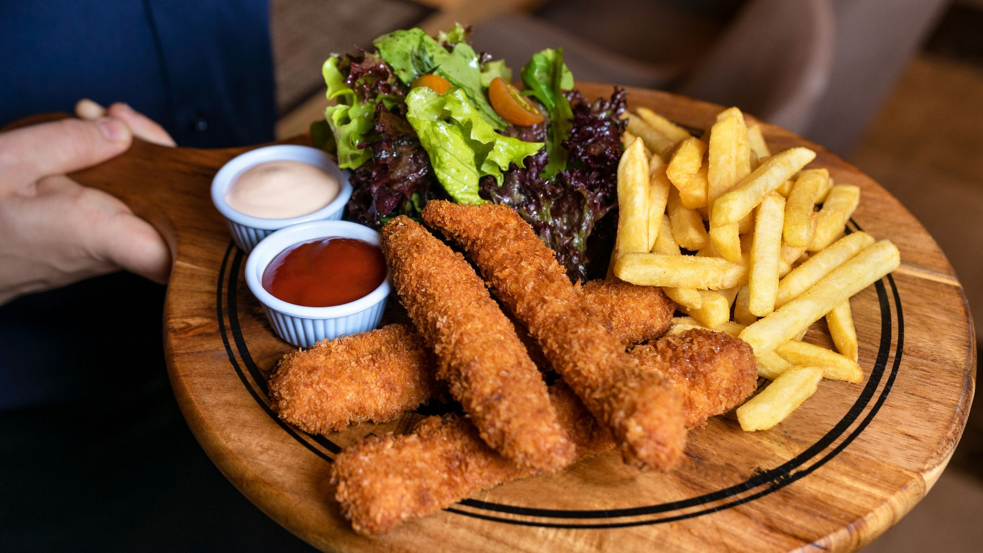 fried food with green vegetable on brown wooden round plate
