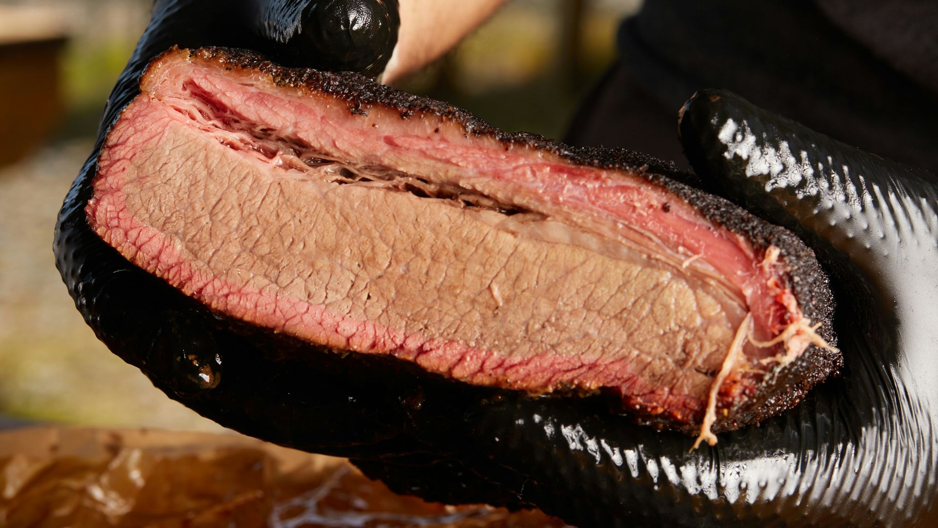 person holding raw meat during daytime