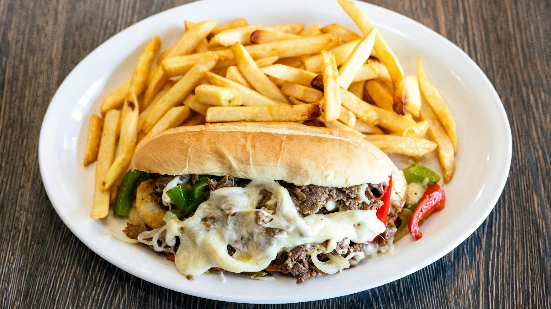 A white plate topped with a sandwich and fries