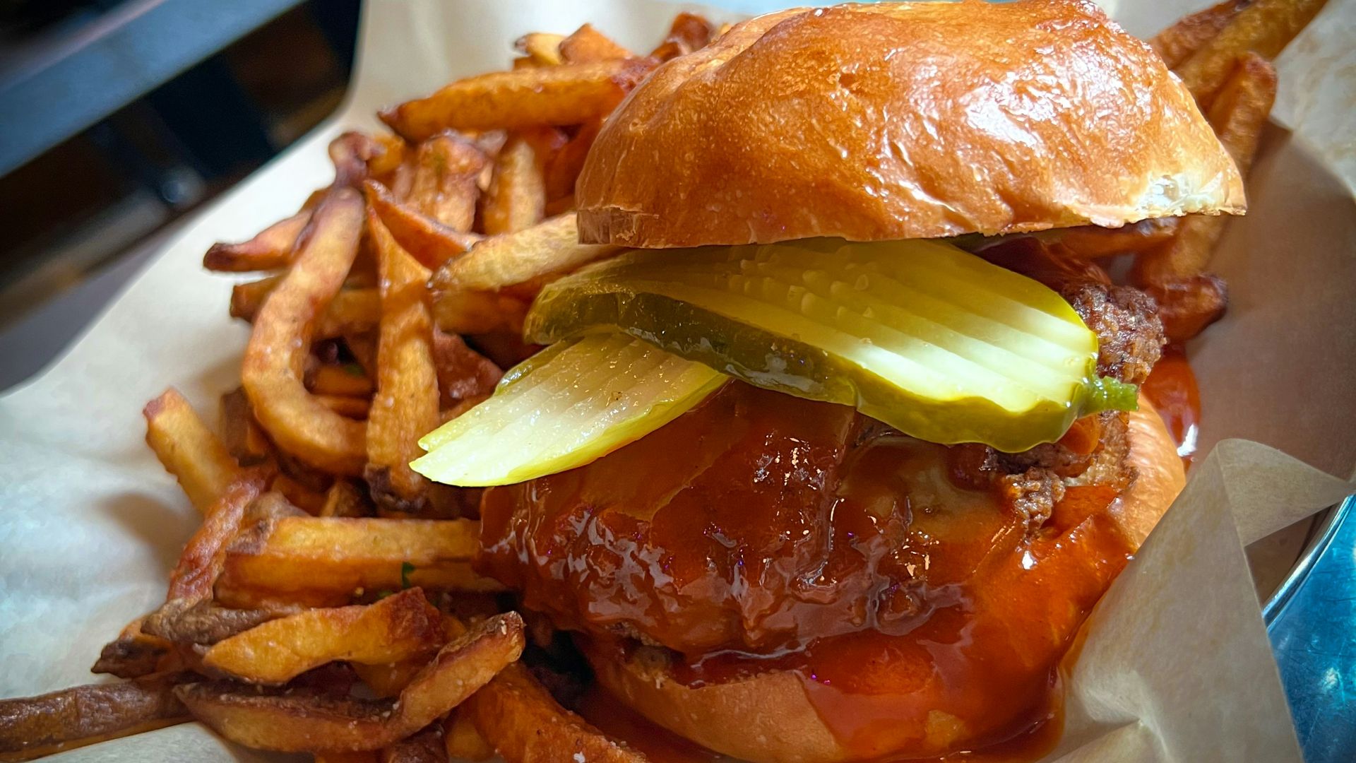 a hamburger with pickles and onions on a roll