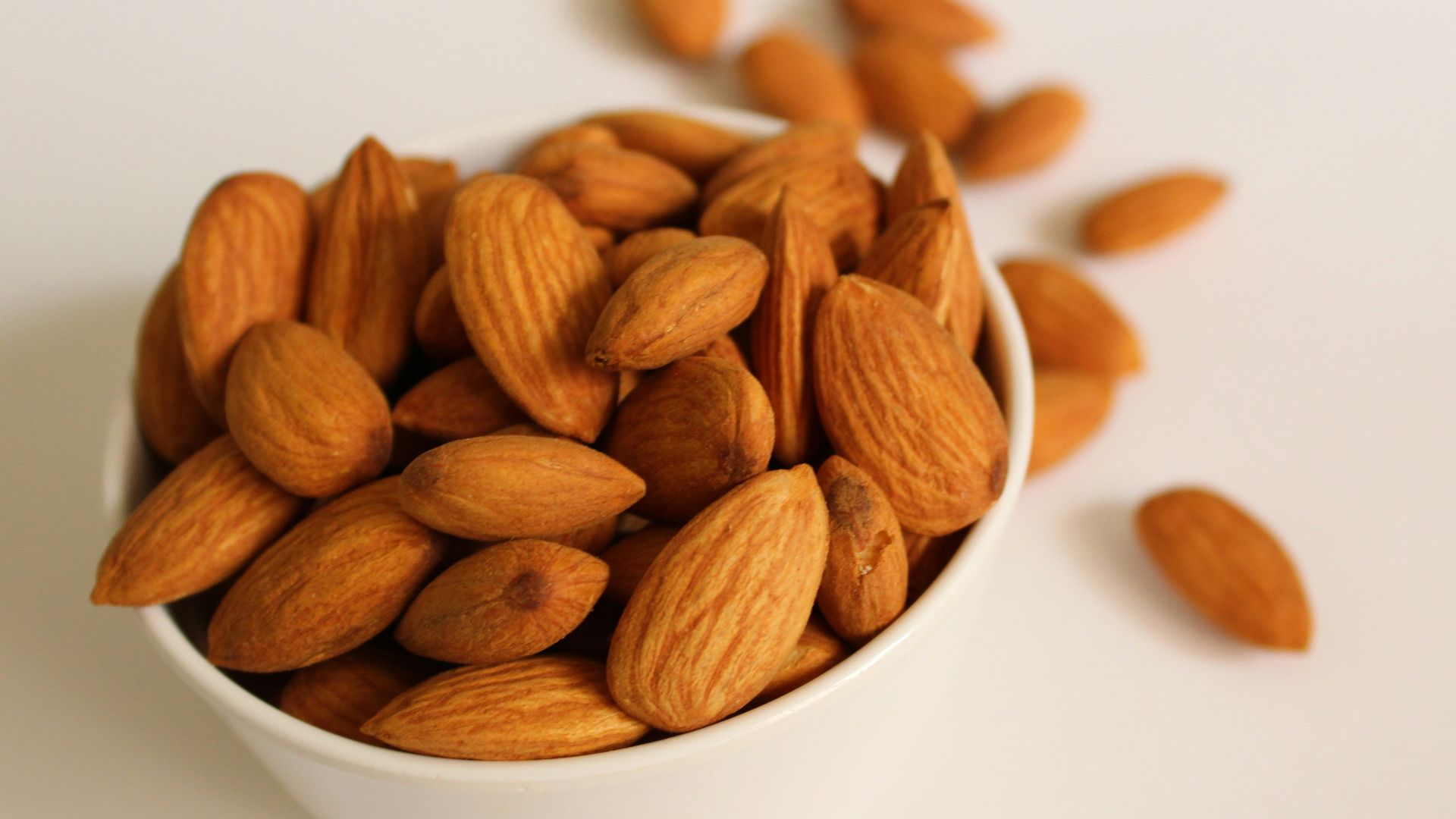 brown almond nuts on white ceramic bowl