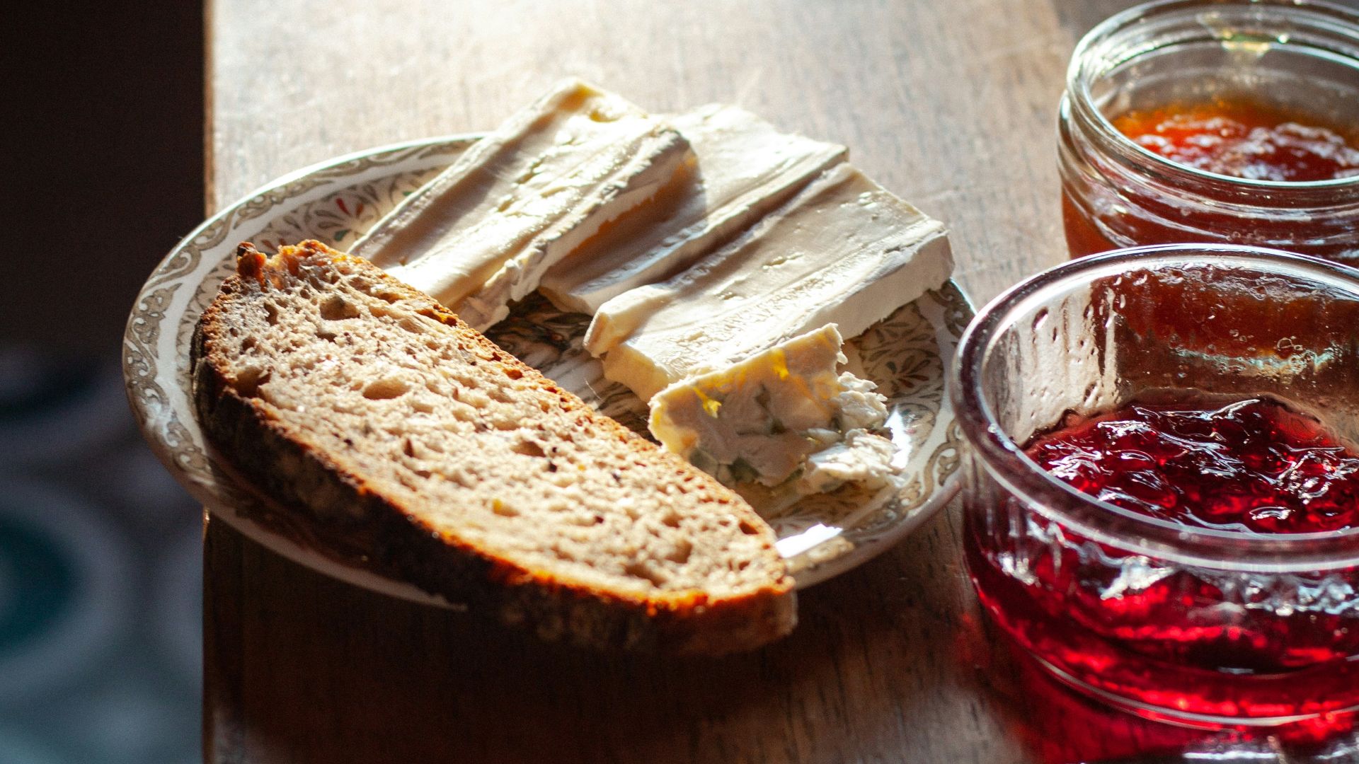 sliced bread on clear glass bowl beside stainless steel bread knife