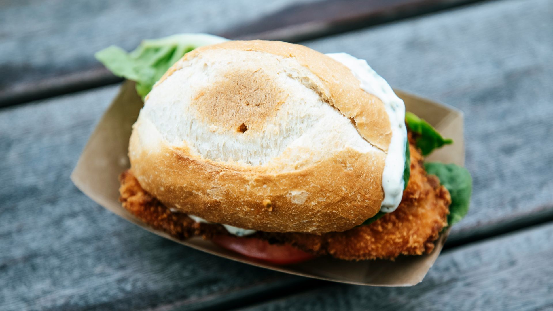 a fried chicken sandwich on a wooden table