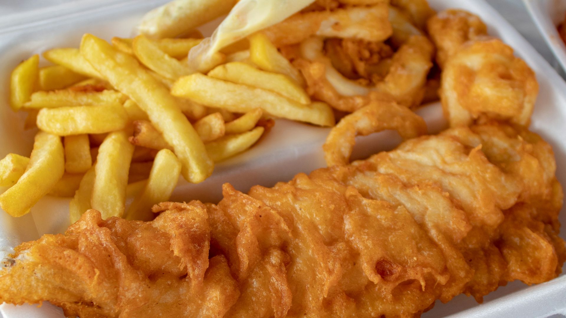 cooked meat and French fries in white disposable plate