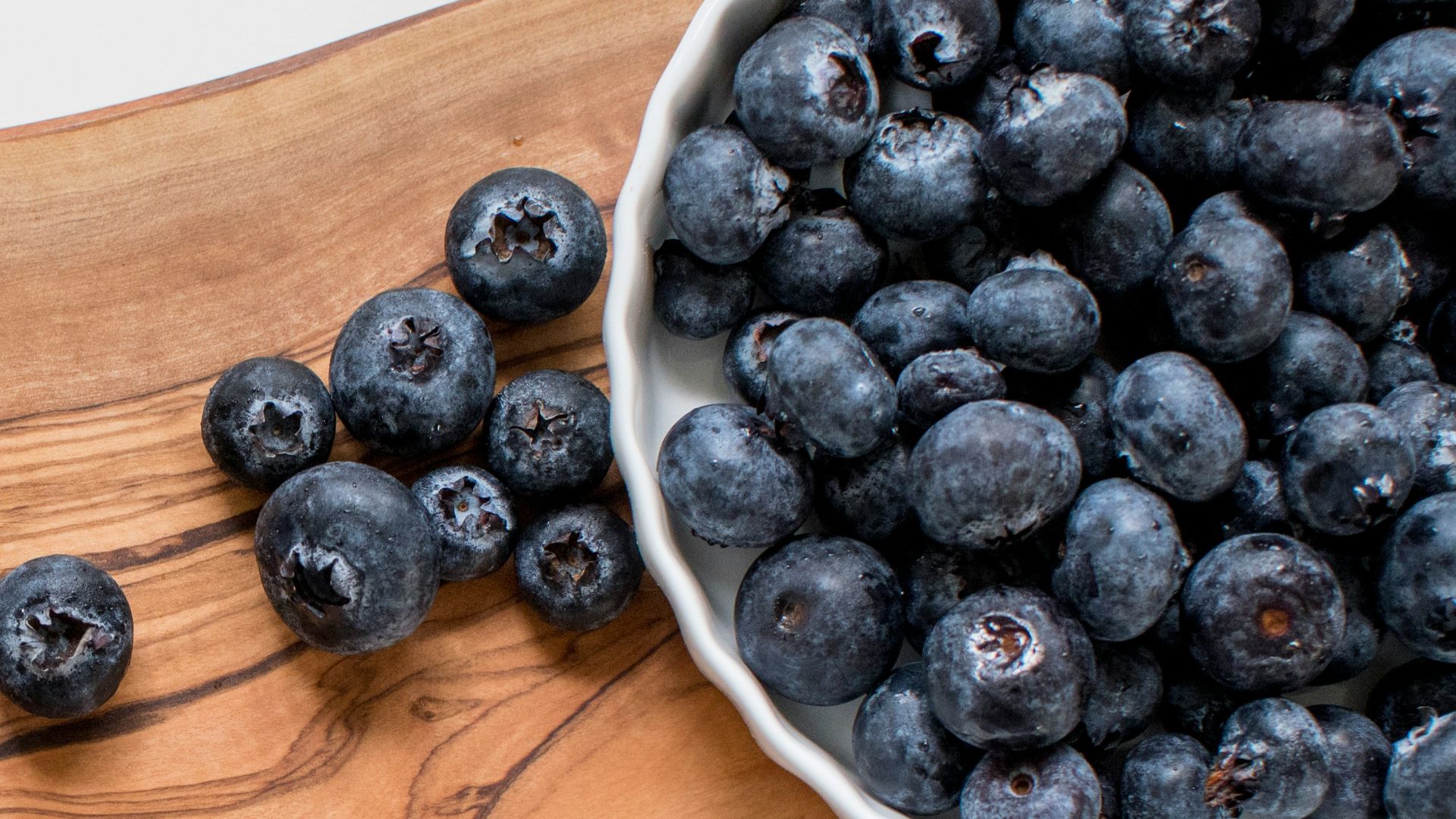 black berries on brown wooden chopping board
