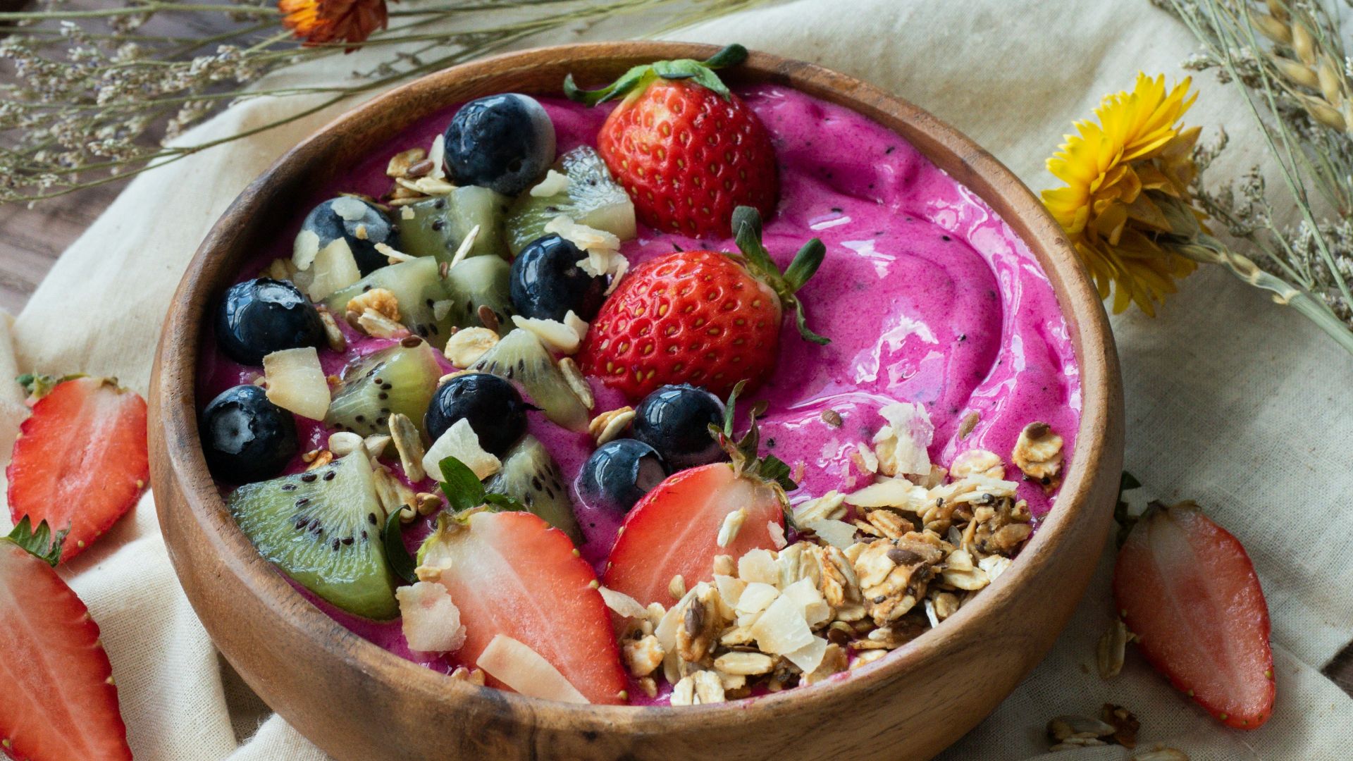 red and black berries on brown wooden bowl