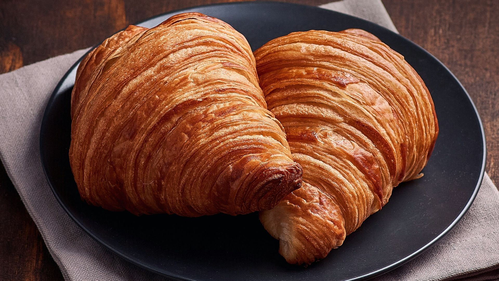 bread on brown wooden tray beside white ceramic mug