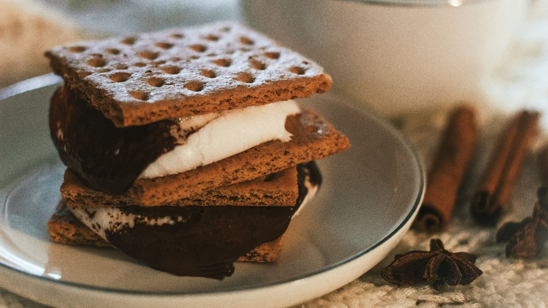 a stack of waffle sandwiches on a plate next to a cup of coffee