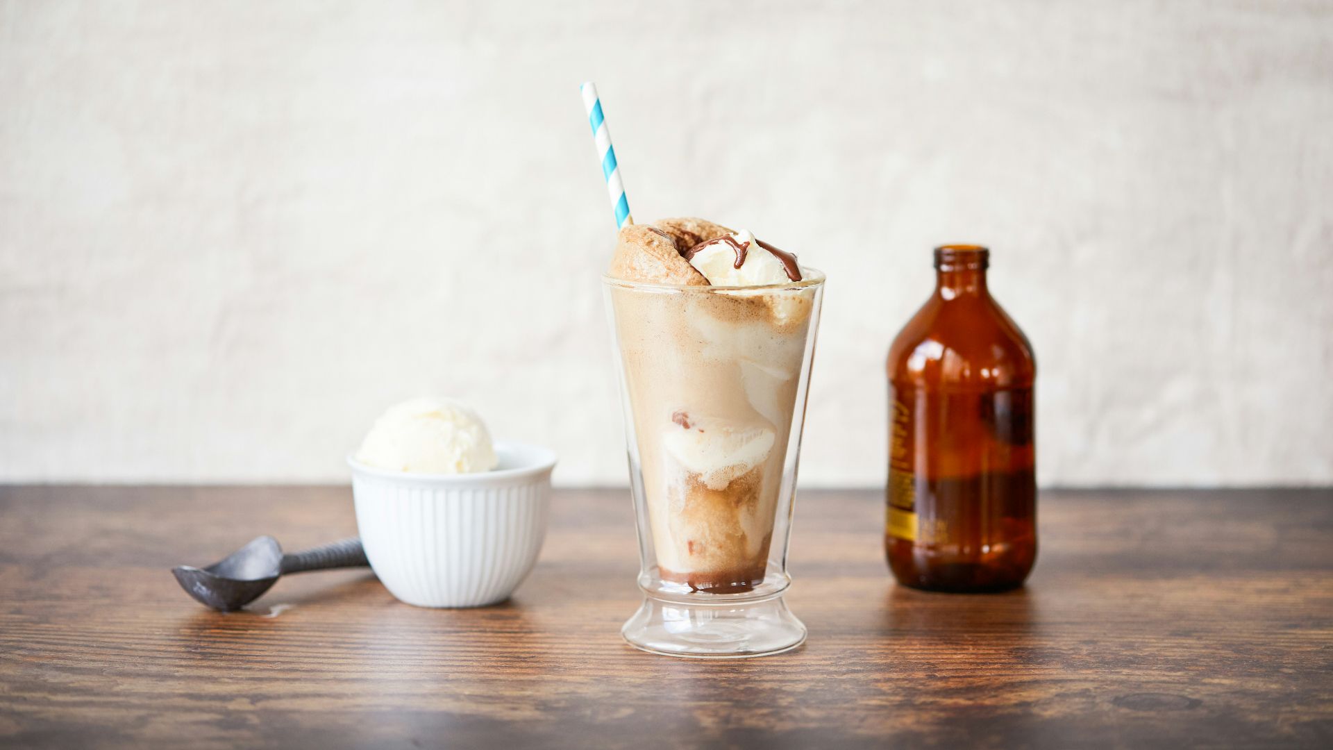 a glass of ice cream next to a bottle of beer