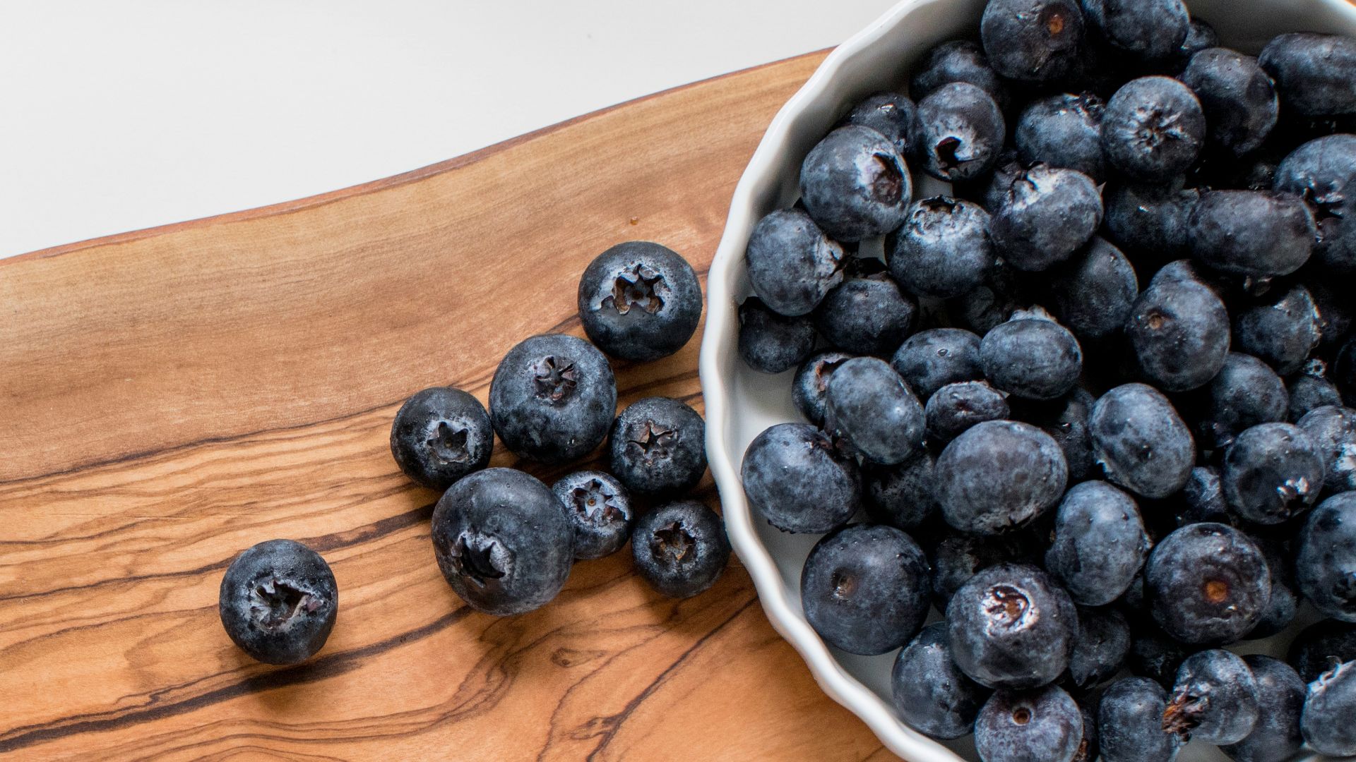 black berries on brown wooden chopping board