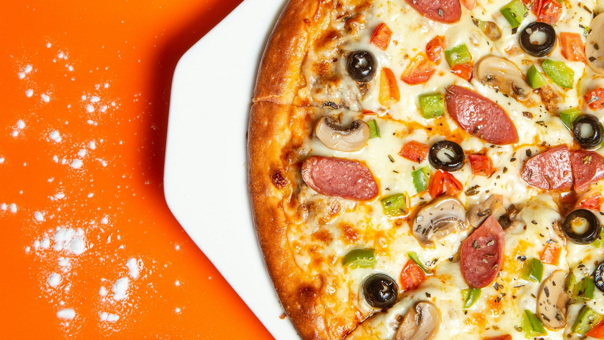 pizza with pepperoni and cheese on orange table