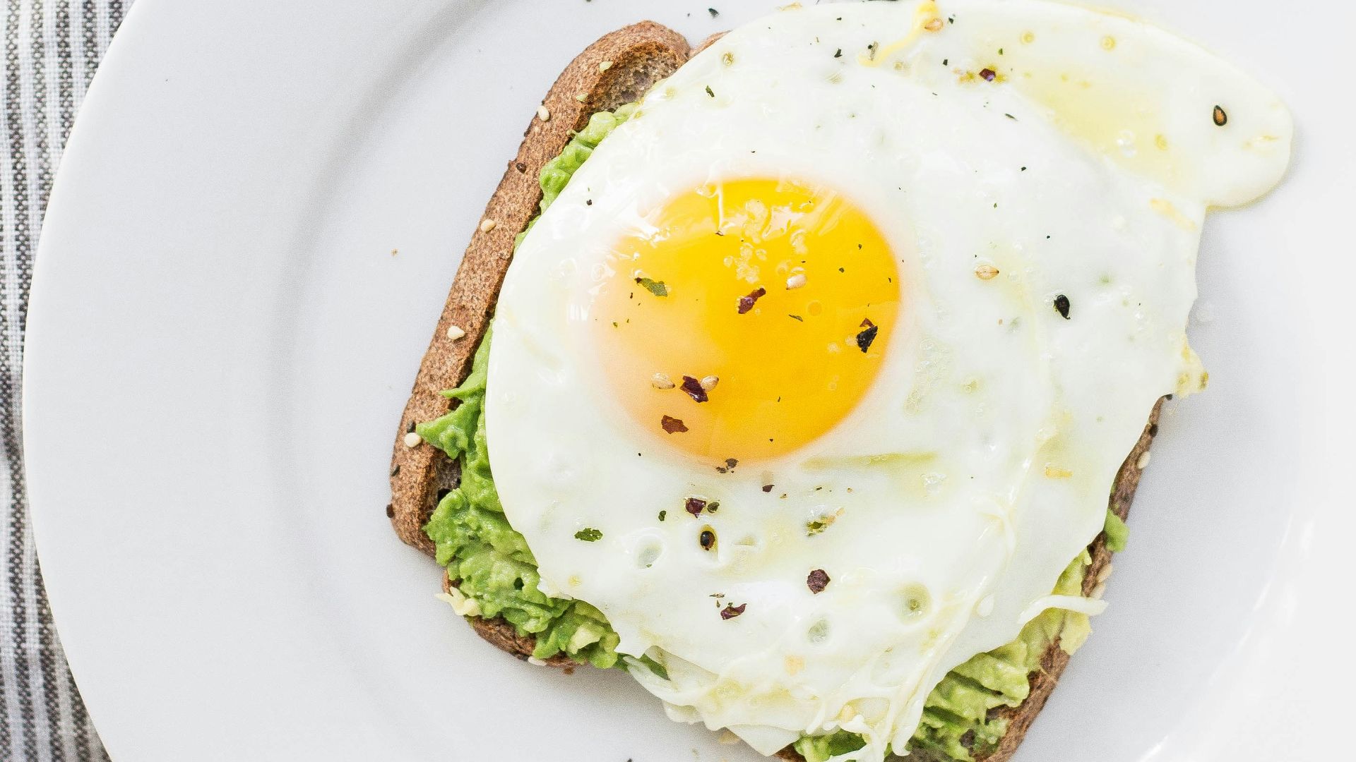sunny side up egg, lettuce, bread on white ceramic plate
