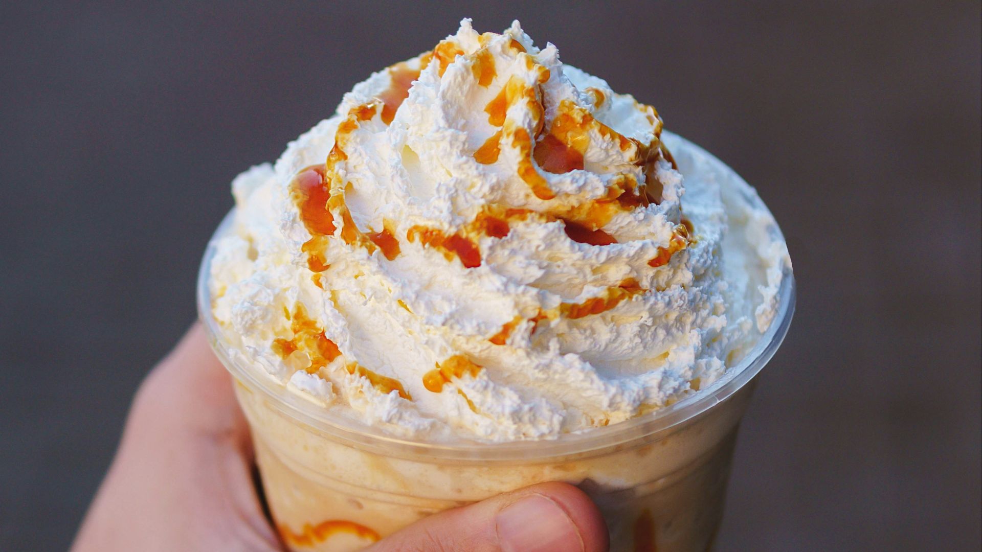 a hand holding a cup of ice cream