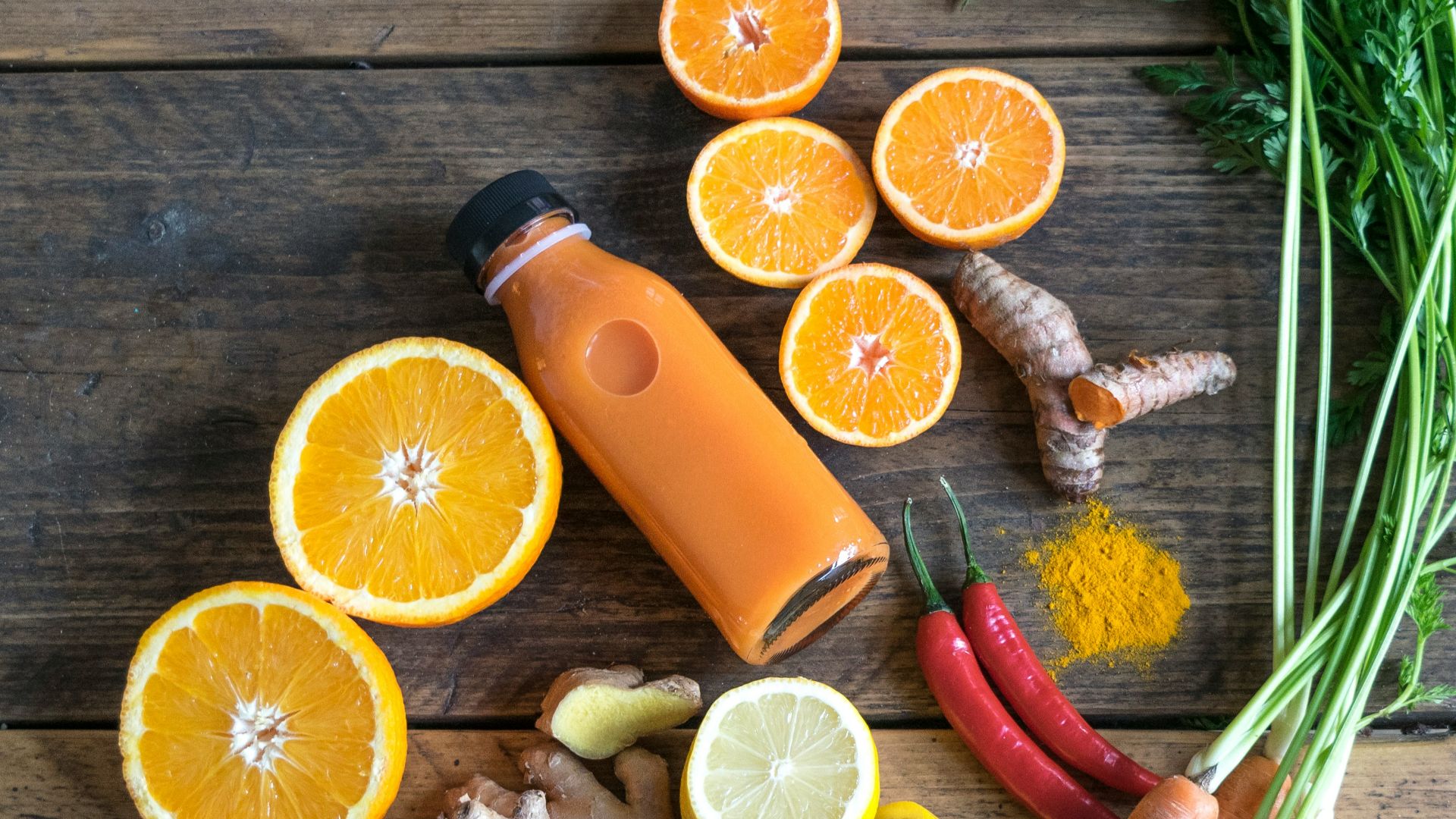 sliced orange fruit and green leaves on brown wooden table