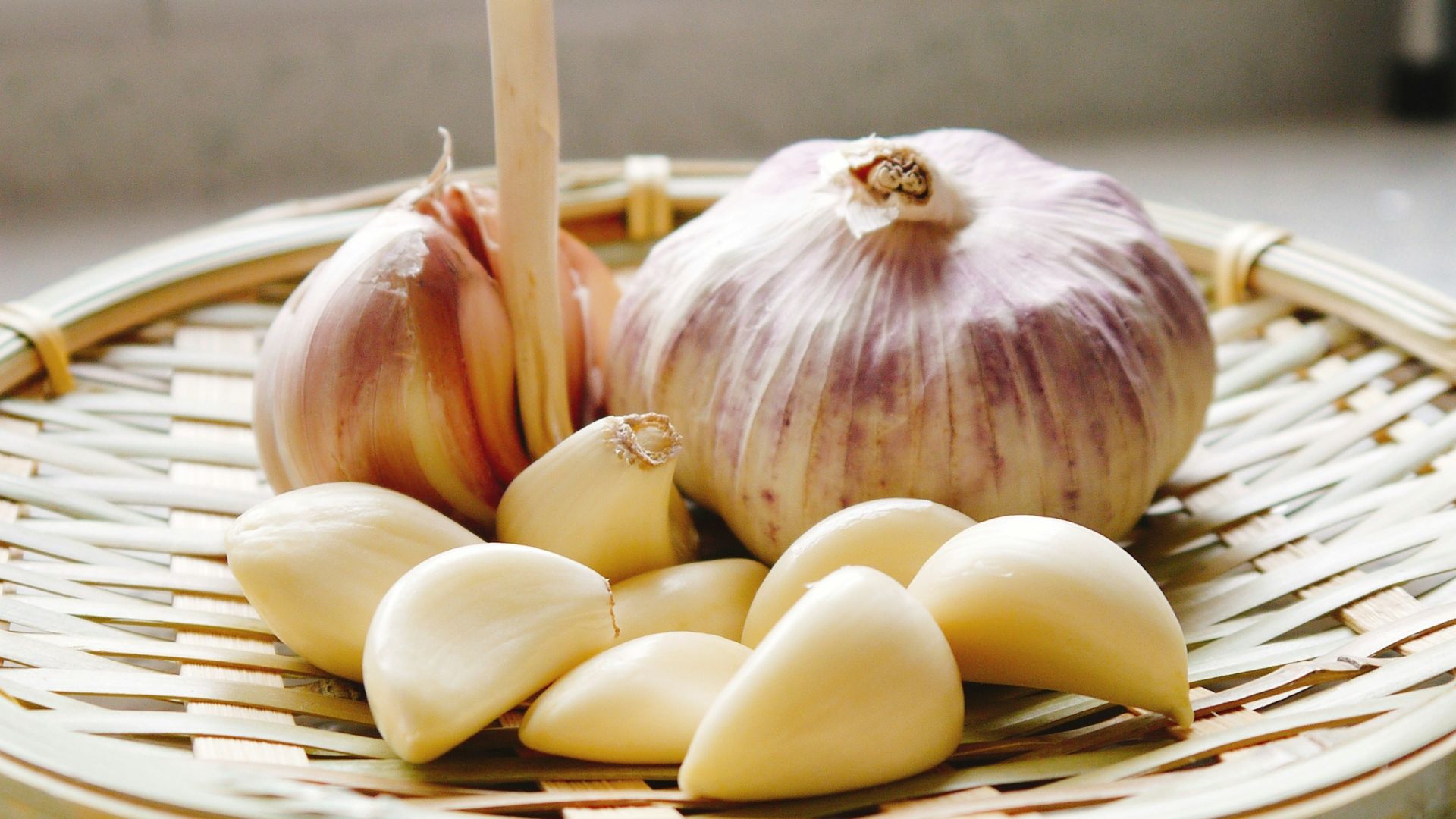 a basket of garlic and garlic bulbs on a counter