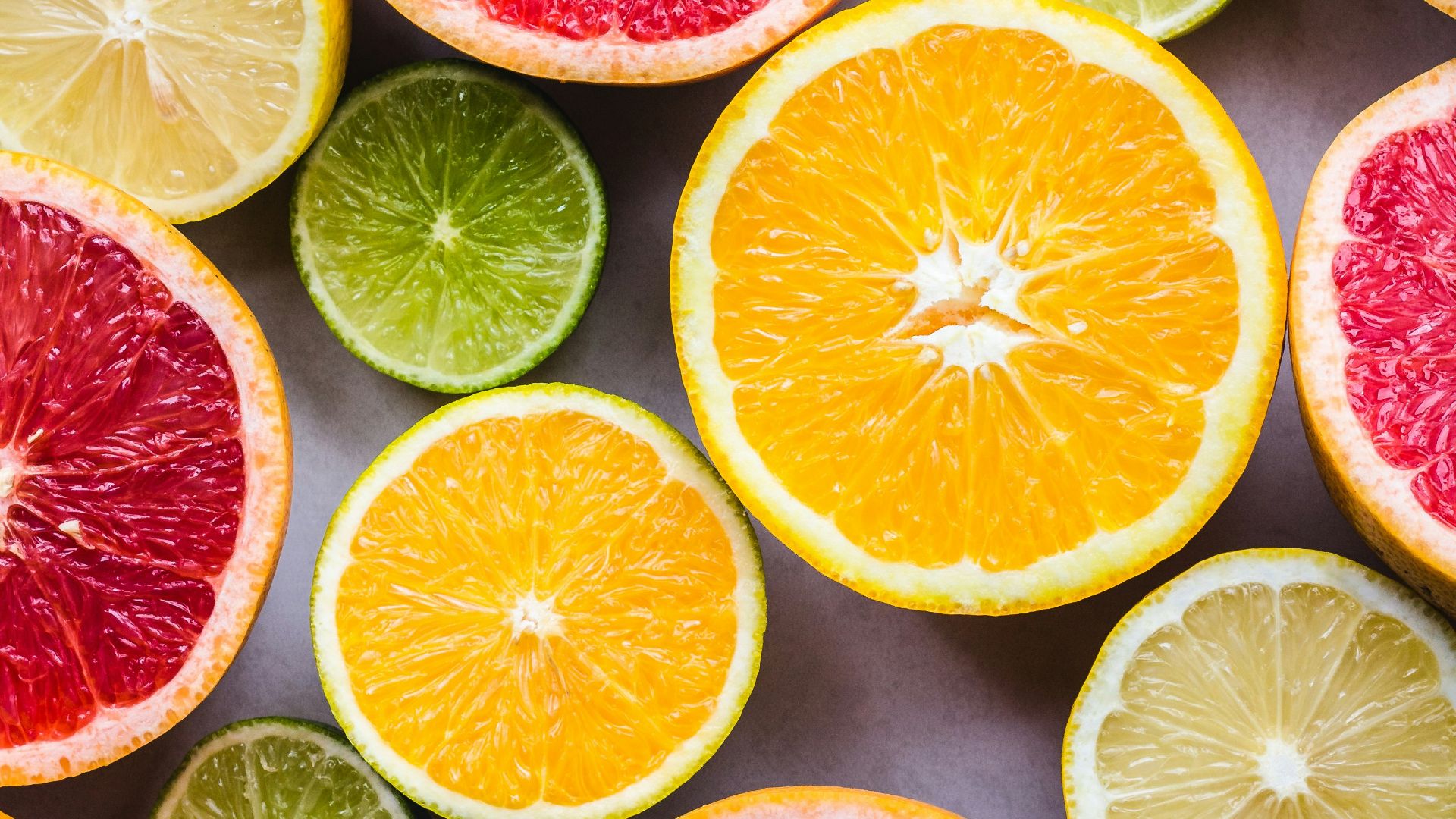 flat lay photography of sliced pomegranate, lime, and lemon
