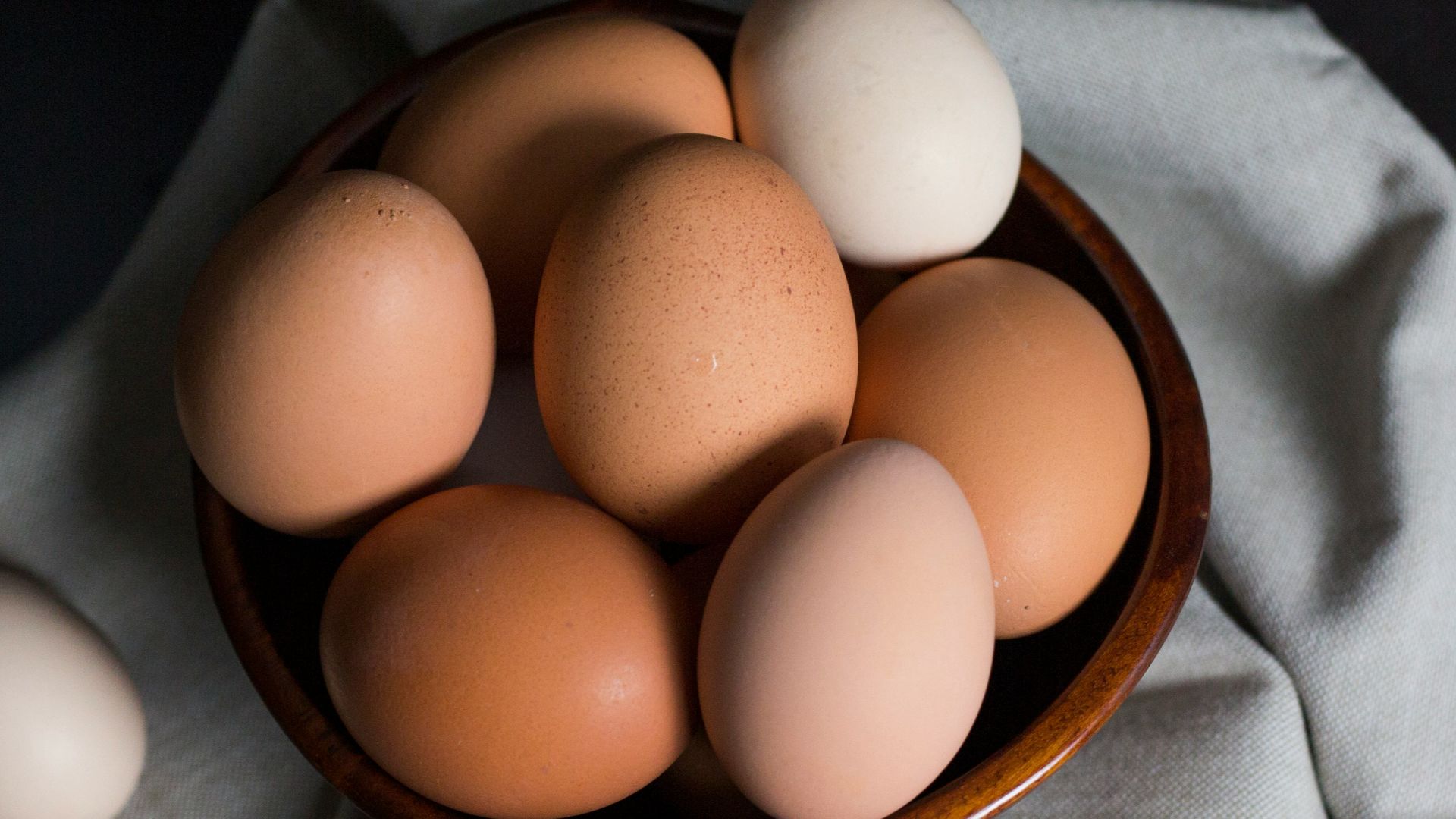 beige and white eggs on brown wooden bowl
