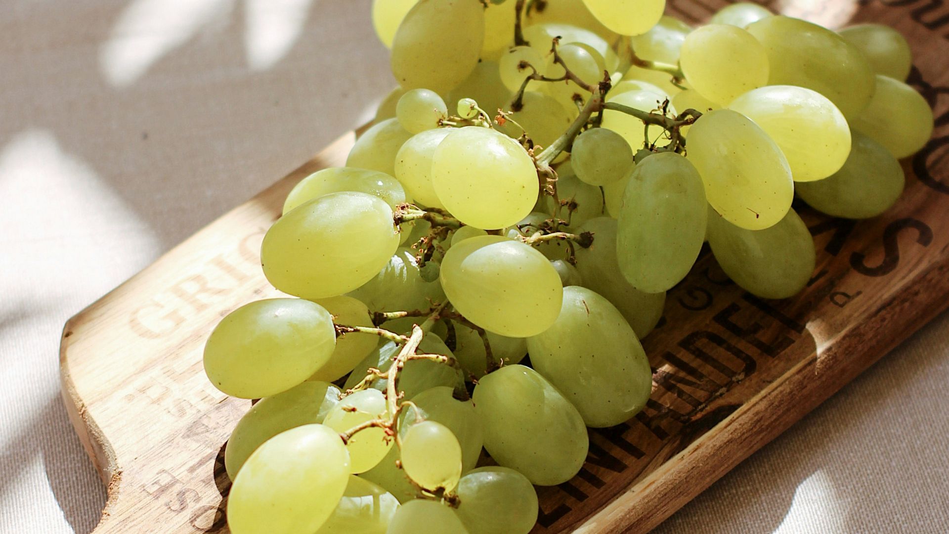 green grapes on brown wooden chopping board